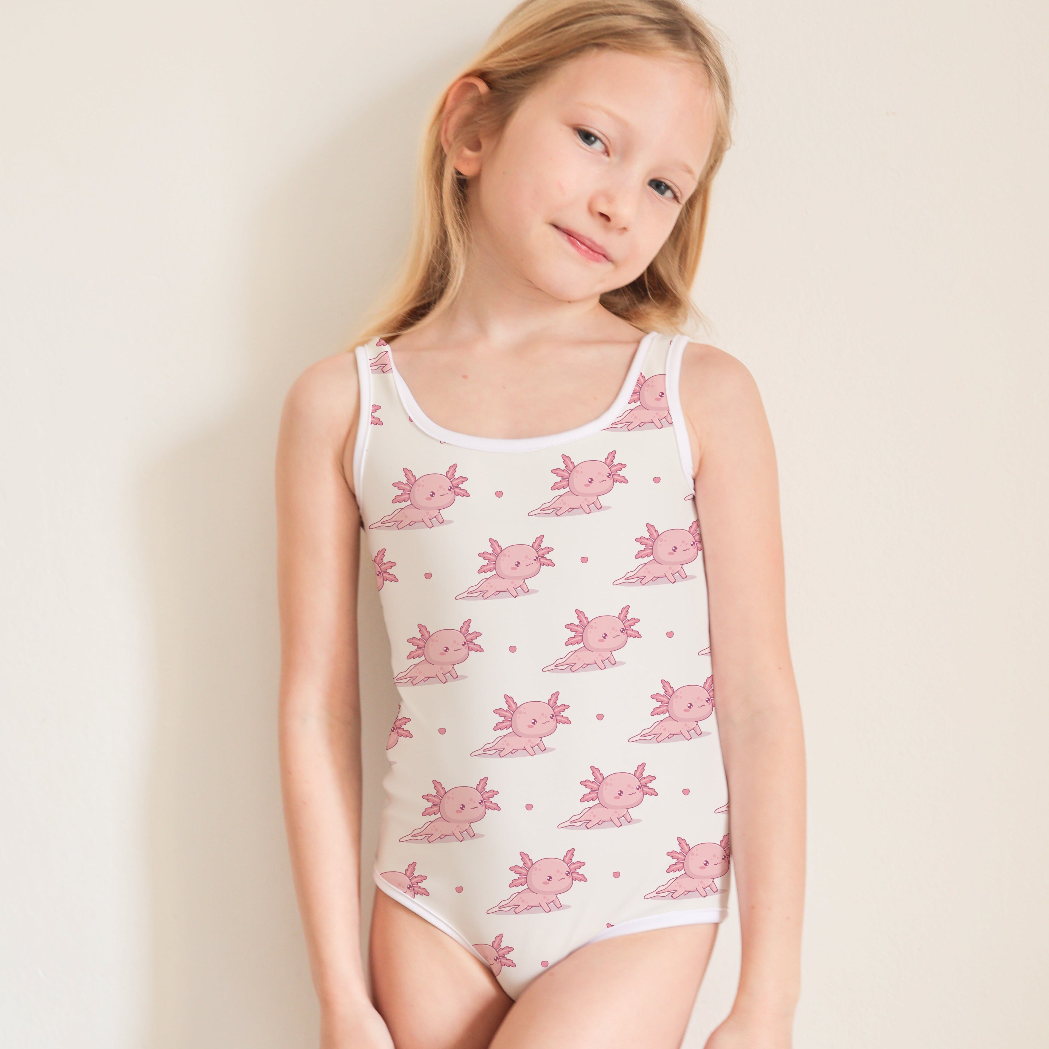 Young girl wearing a sleeveless swimsuit with pink floral pattern on a beige background