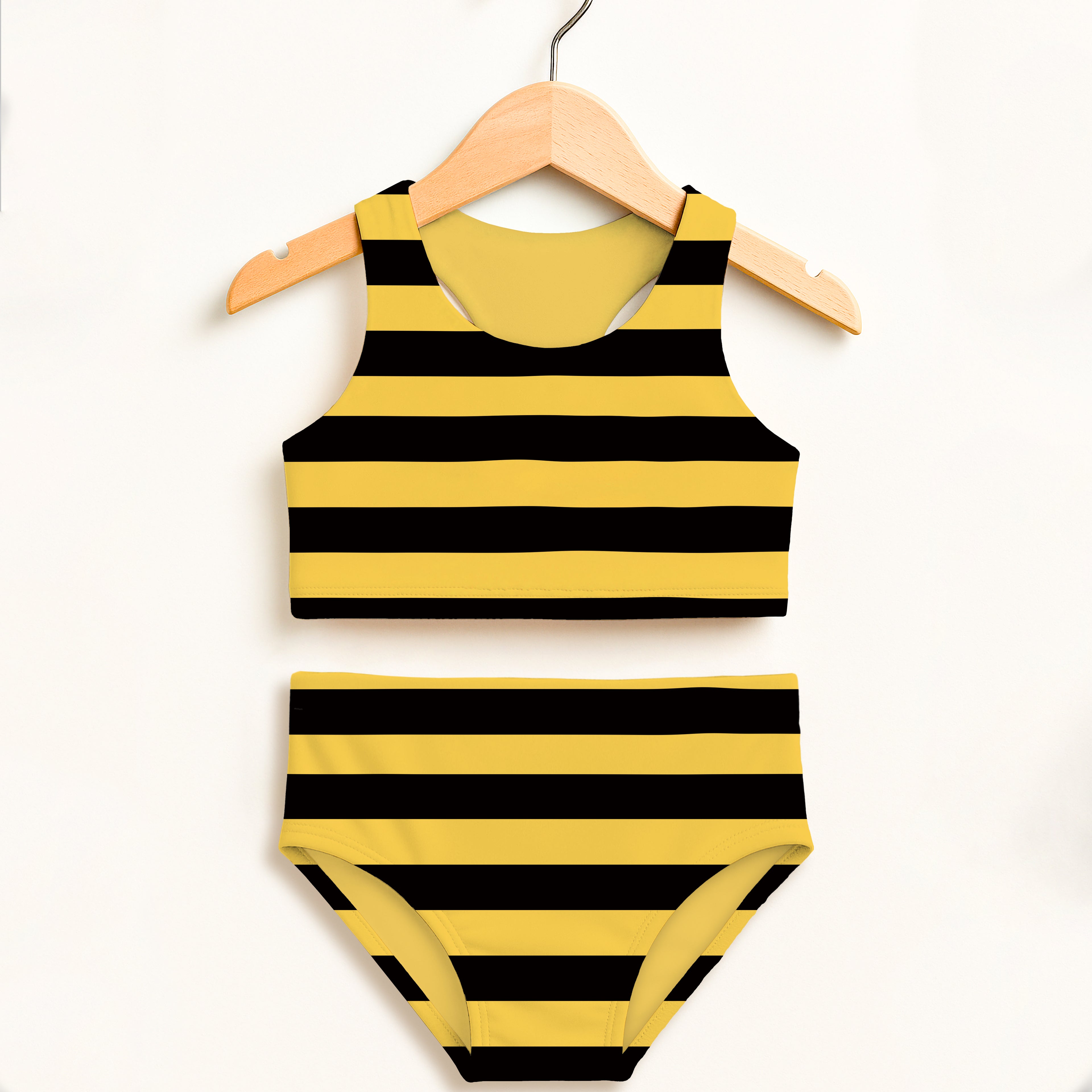 Yellow and black striped girls bee stripe two piece swimsuit hanging on wooden hanger with upf 50+ sun protection