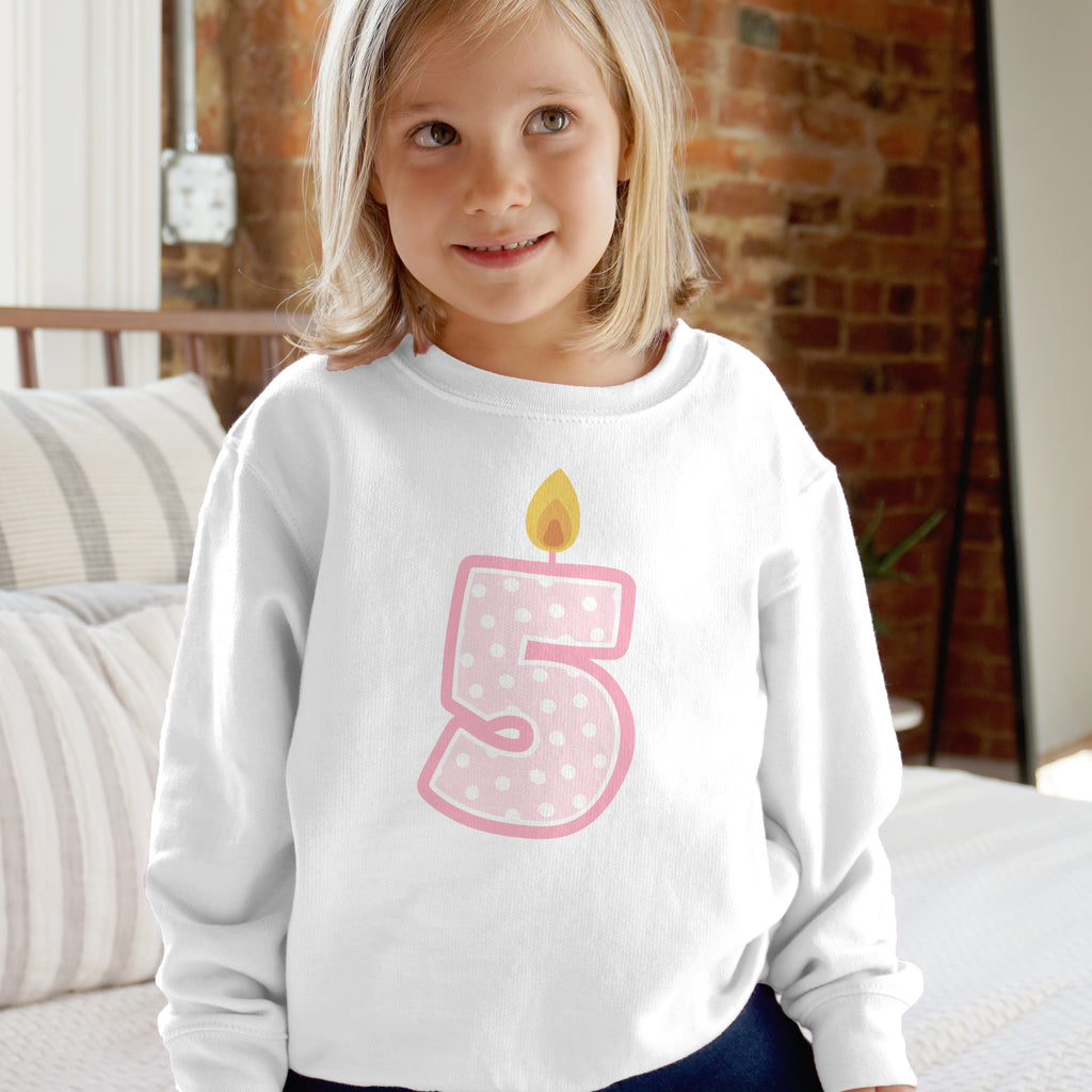 Child wearing a white birthday sweatshirt with a pink number 5 and candle design