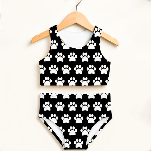 Girls black and white paw print two piece swimsuit hanging on wooden hanger with double layered upf 50+ fabric
