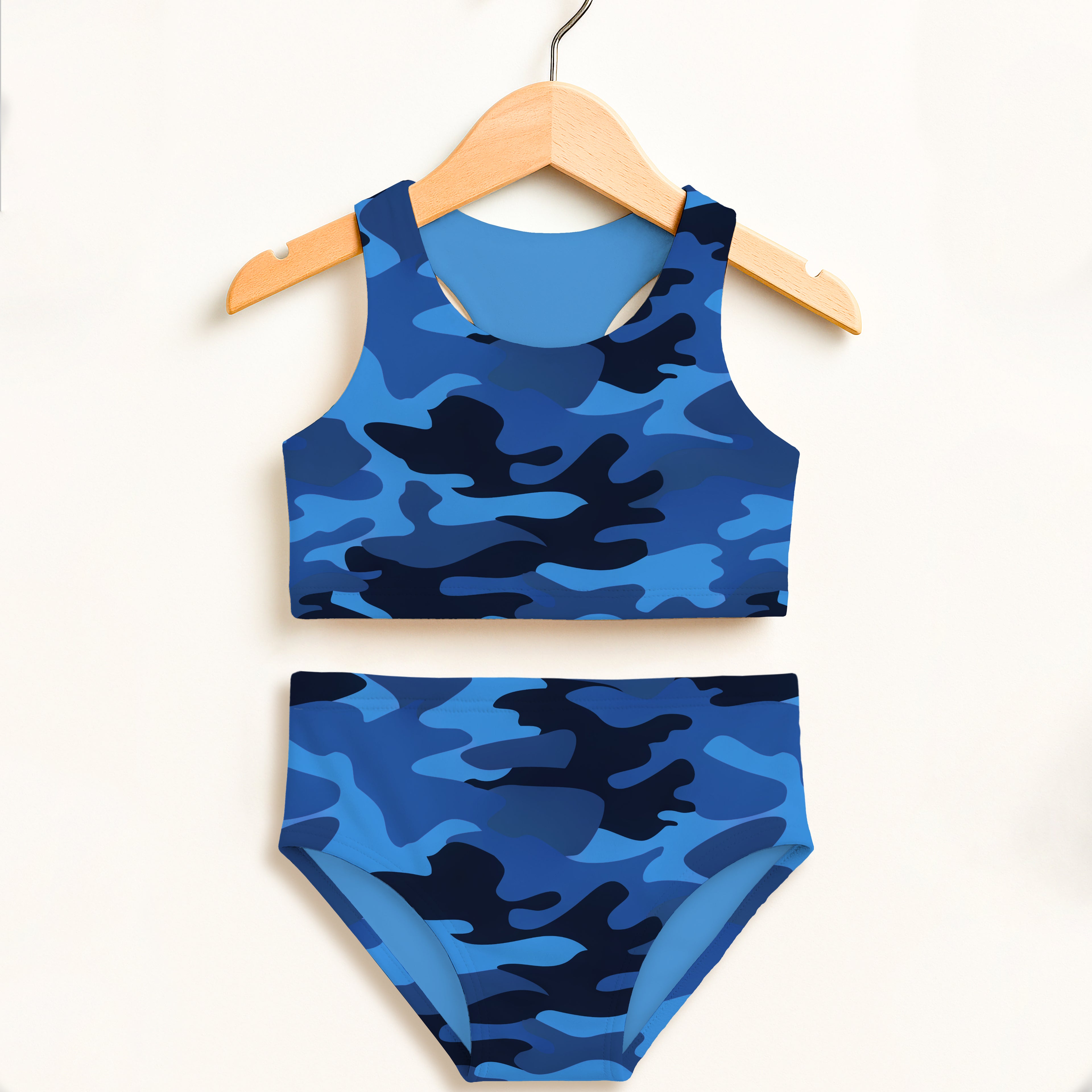 Girls dark blue and black camouflage two piece swimsuit with double layered fabric and upf 50 plus protection hanging on wooden hanger