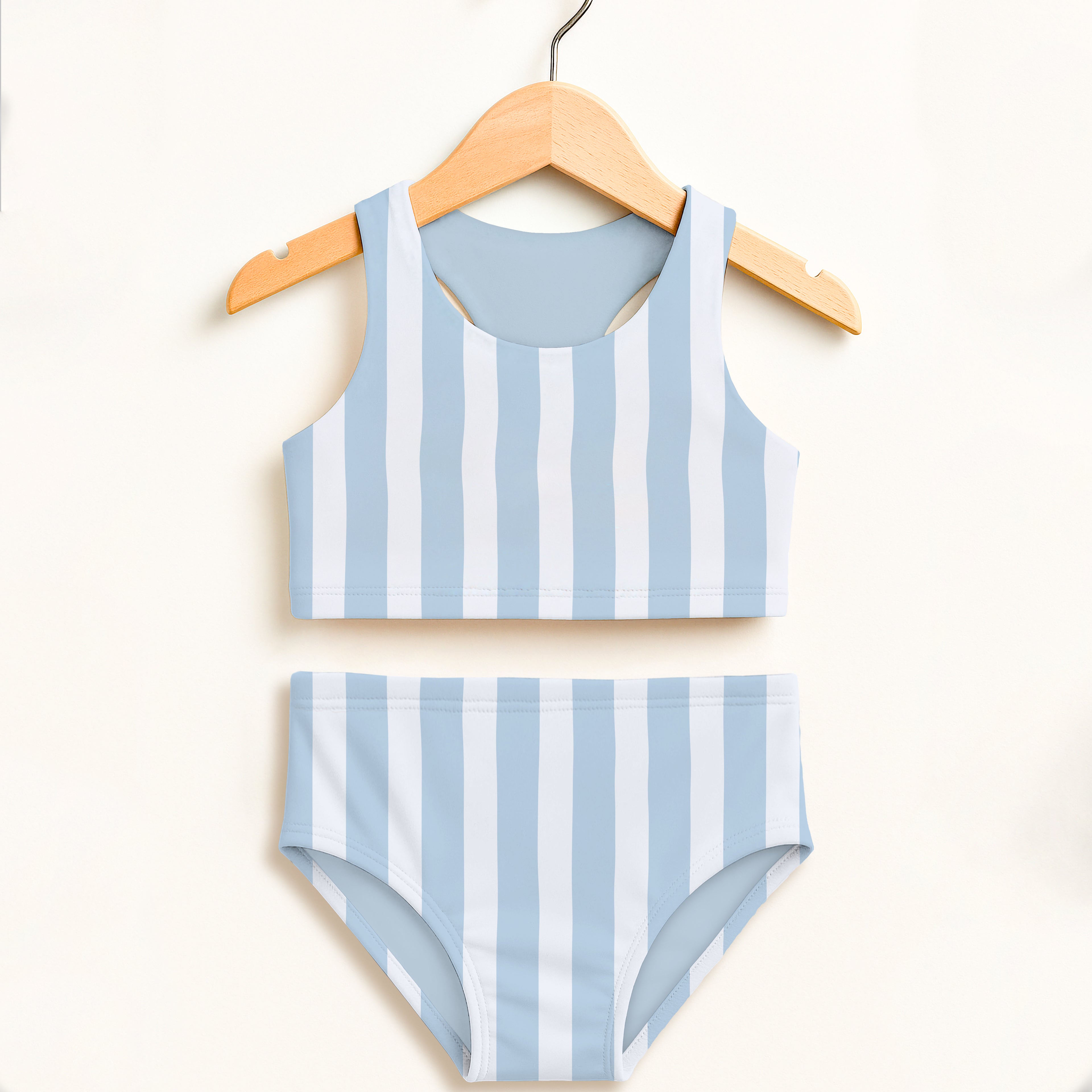 Girls blue stripe two piece swimsuit with light blue and white stripes hanging on wooden hanger featuring upf 50+ protection