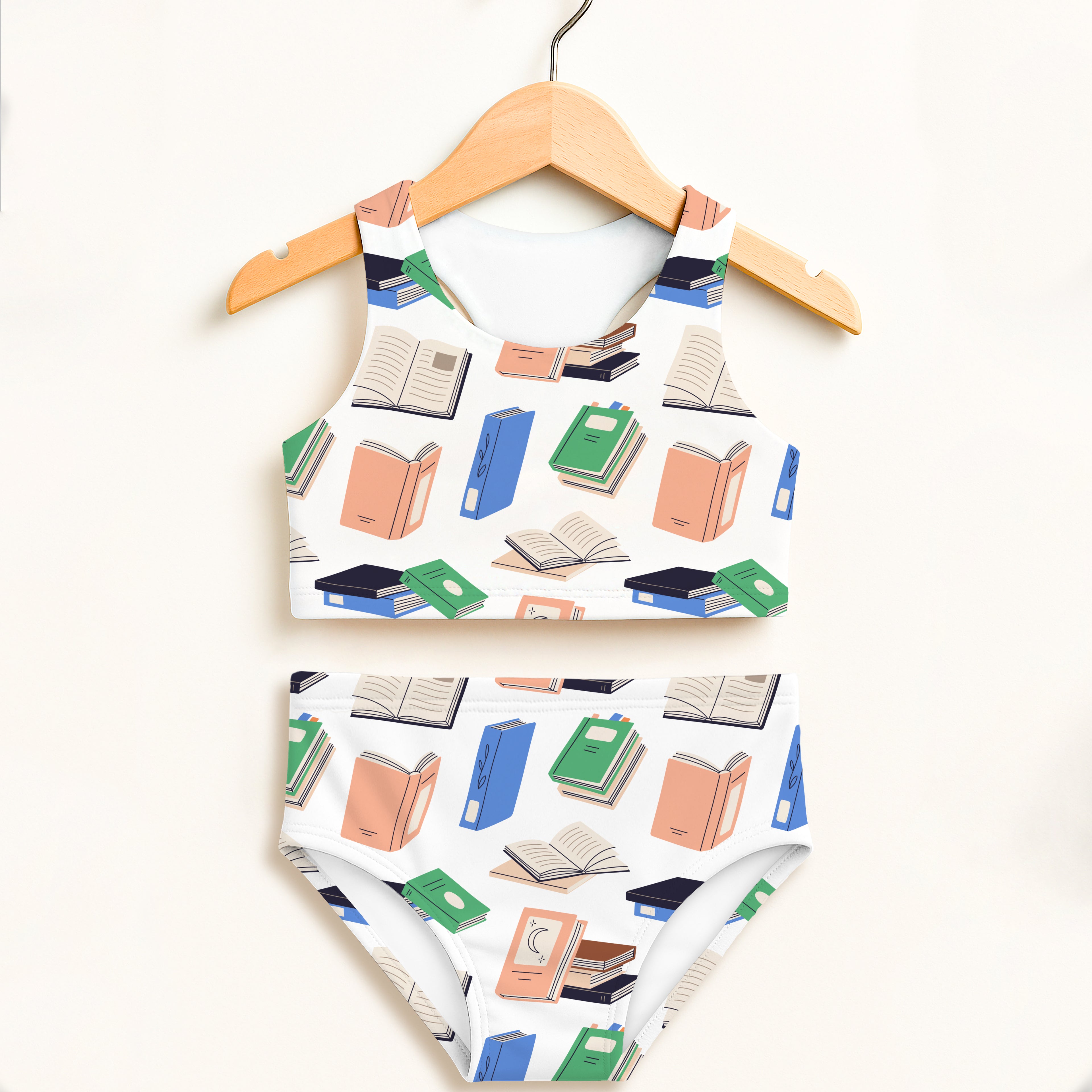 White two-piece swimsuit with illustrated books pattern in green blue and peach high waisted double layered upf 50+