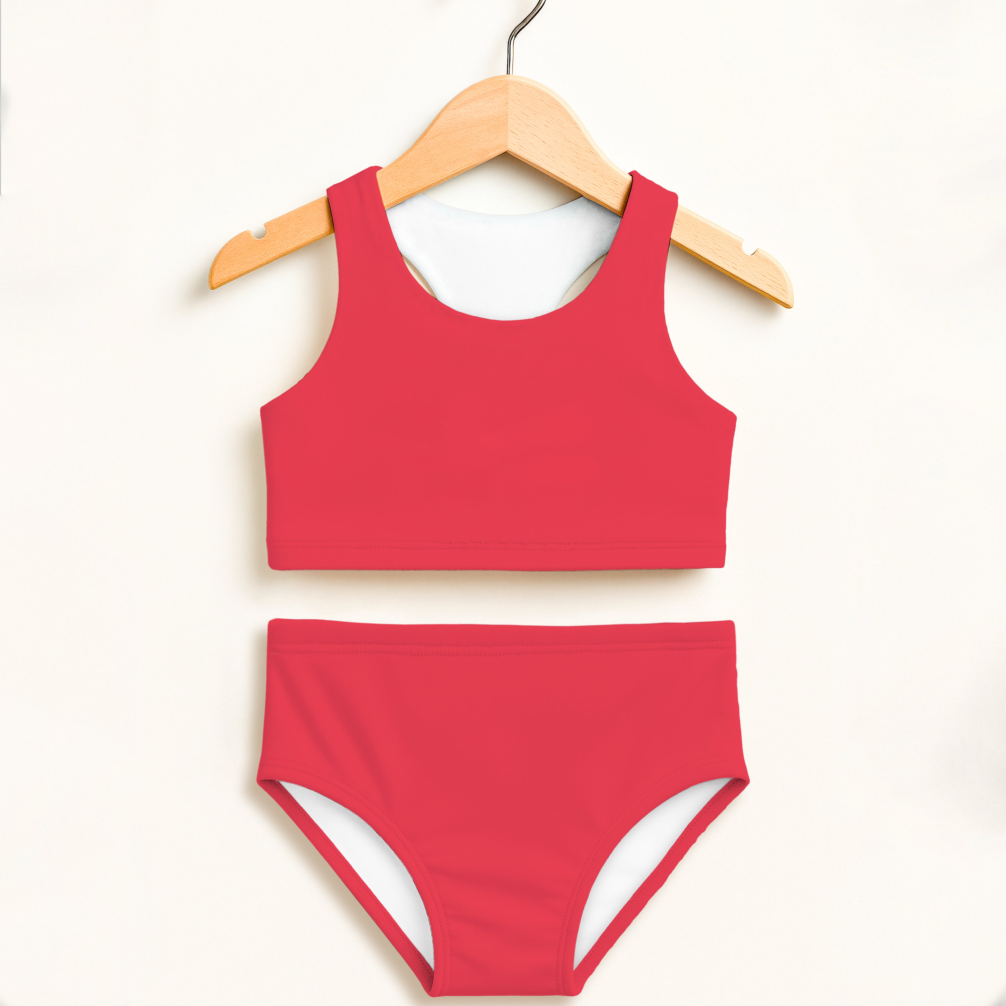 Girl wearing a red two-piece swimsuit with white lining featuring a cropped top and high-waisted bottoms