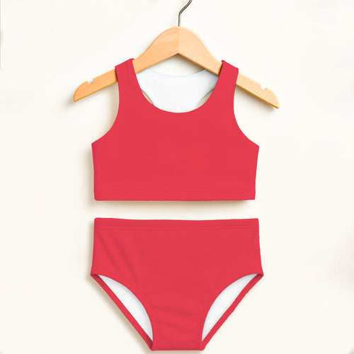 Girl wearing a red two-piece swimsuit with white lining featuring a cropped top and high-waisted bottoms