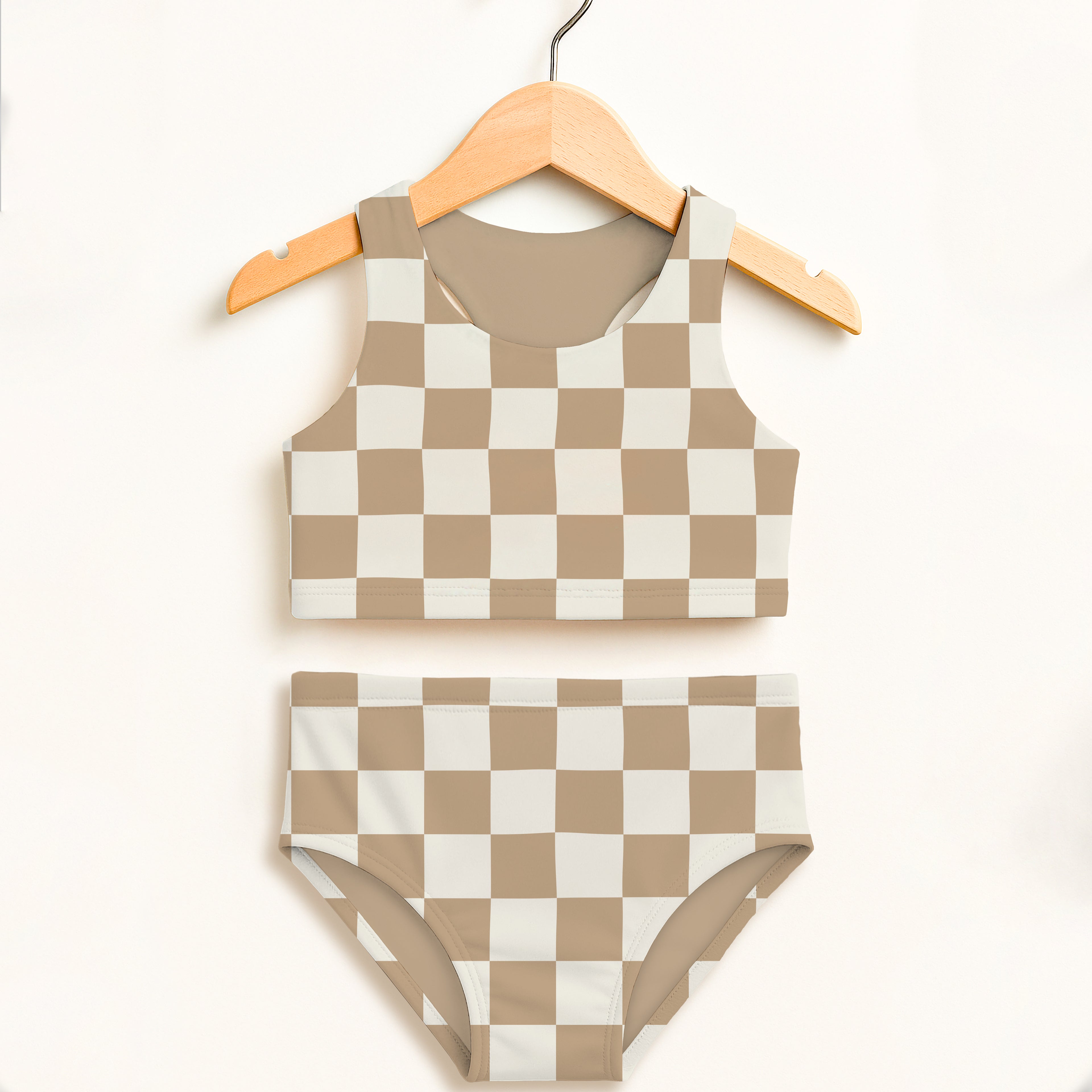 Beige and white checkered girls two piece swimsuit set with double layered fabric and upf 50 plus protection hanging on wooden hanger