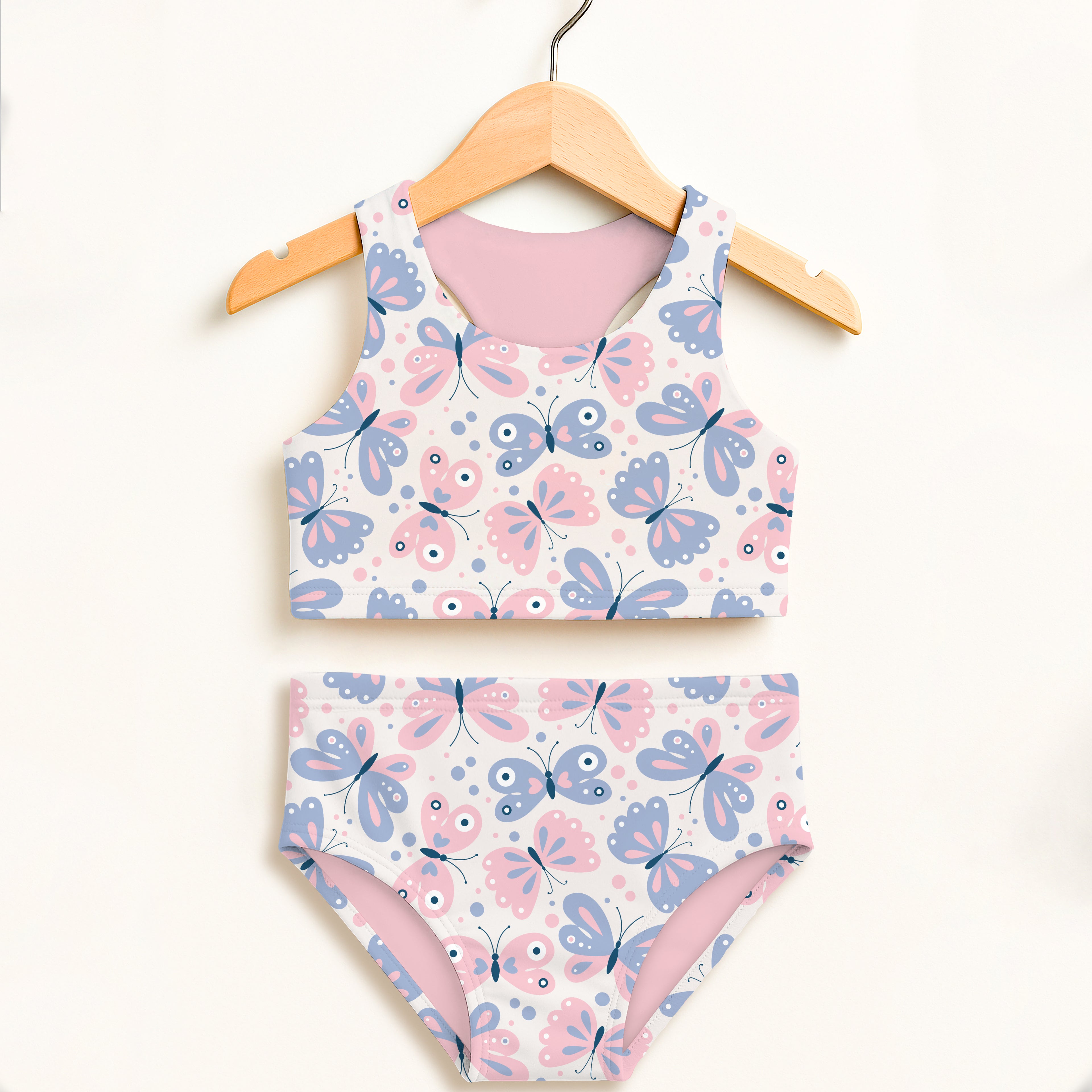 A girls two-piece swimsuit with playful butterfly print in pink and lavender on white double layered upf 50+ fabric