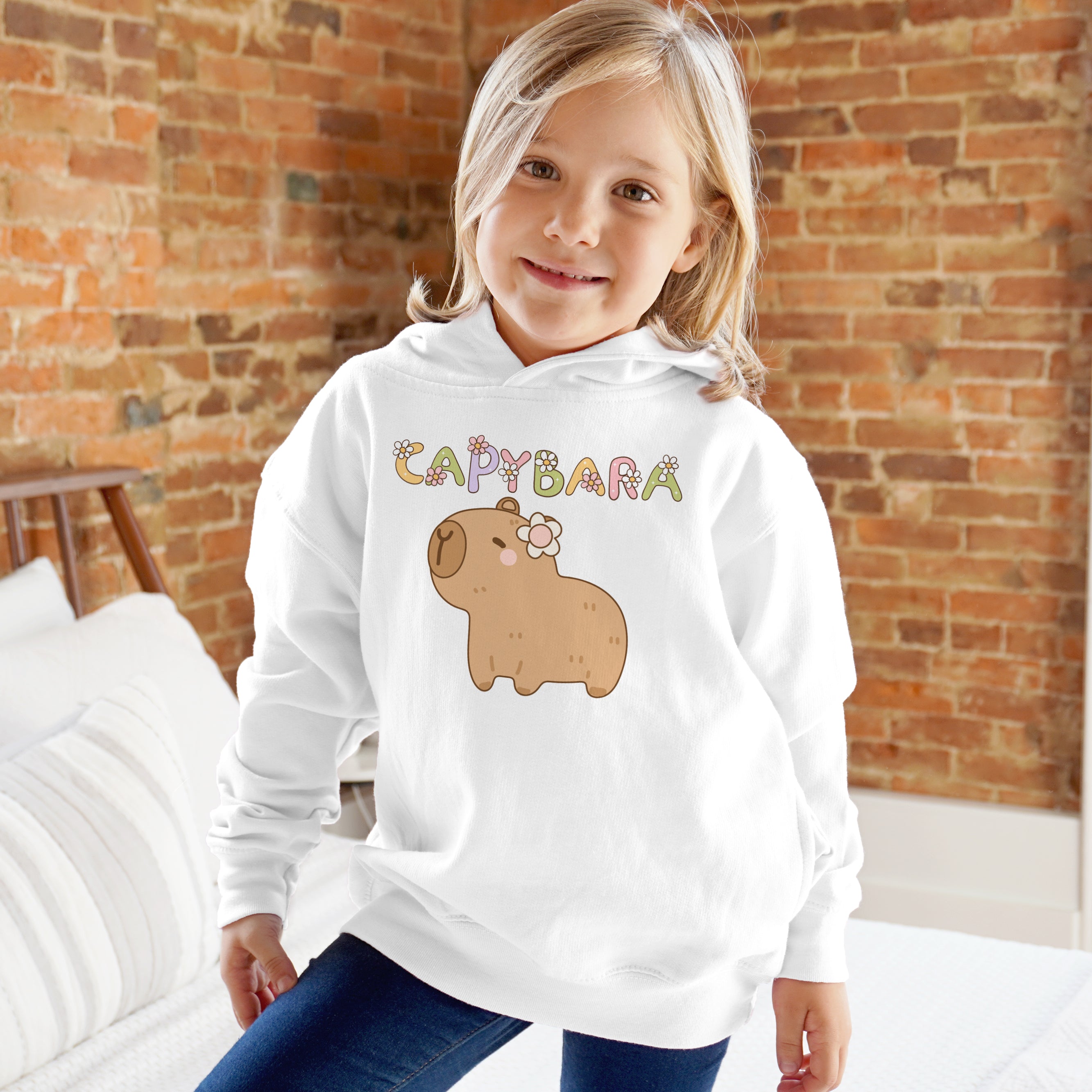 Kids cute white hooded sweatshirt featuring a cartoon capybara with a flower and colorful capybara lettering