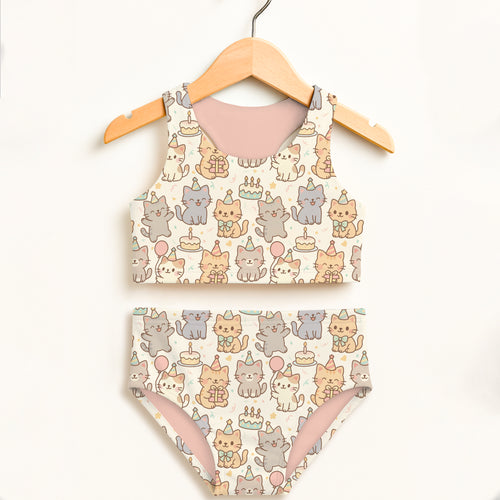 Girls cat birthday two piece swimsuit with cartoon cat pattern soft pink lining off white background double layered upf 50+