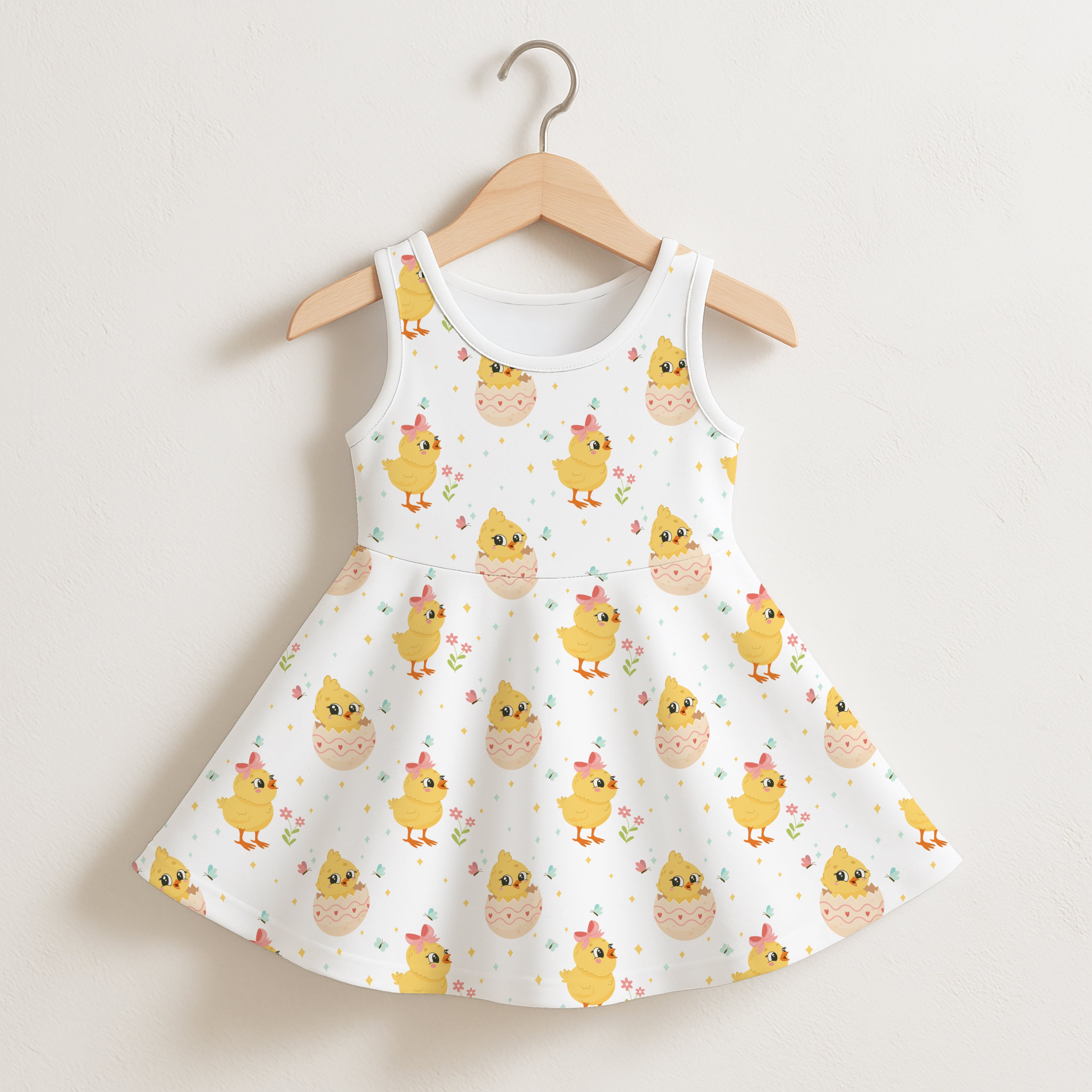 White sleeveless girls dress with playful yellow chicks and eggshell pattern perfect for Easter and springtime wear