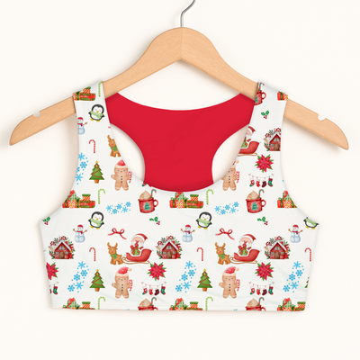 White girls christmas pattern sports bra with red interior featuring snowmen gingerbread men reindeer and holiday houses