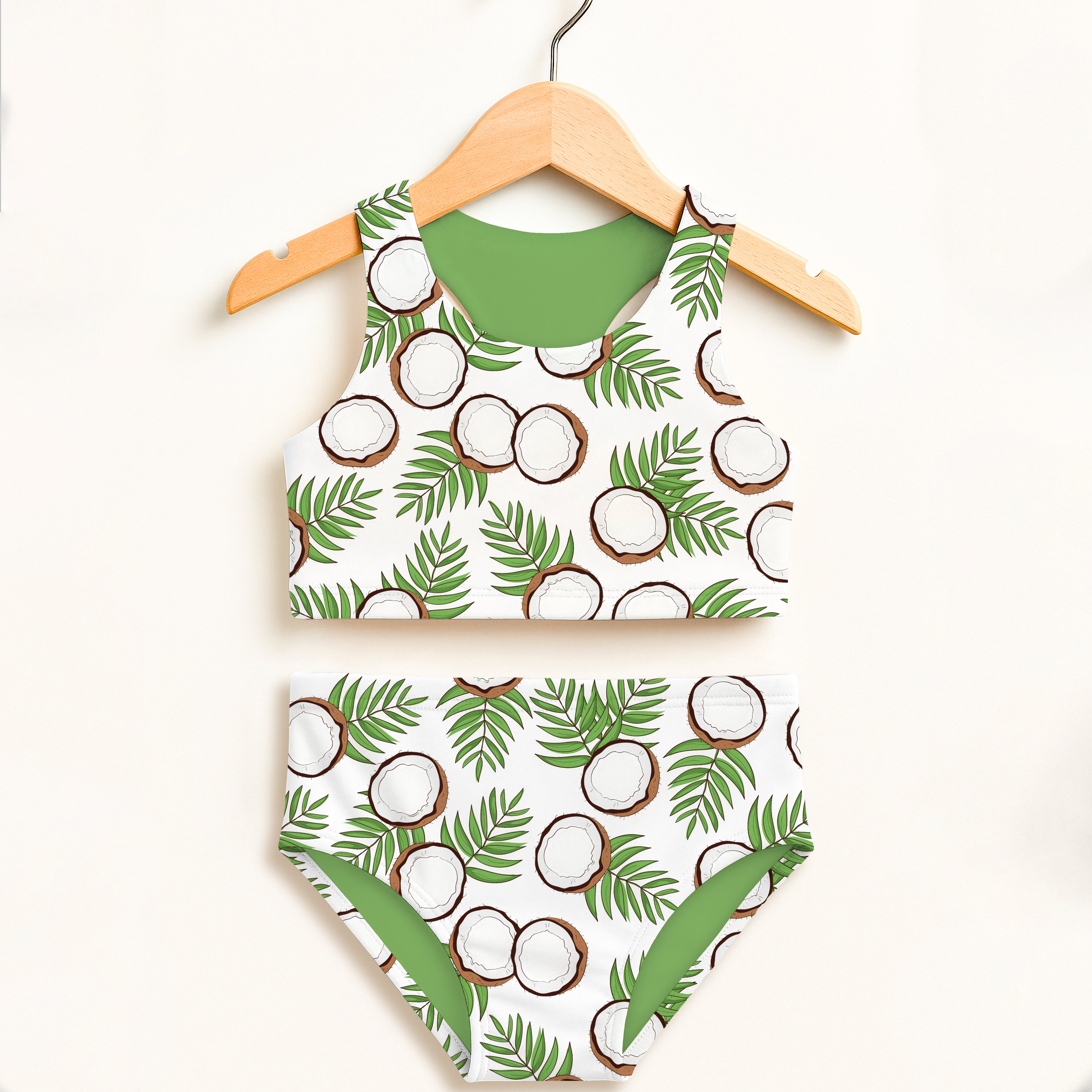 Girls coconut two piece swimsuit with white and green palm print and solid green inner lining featuring UPF 50+ protection