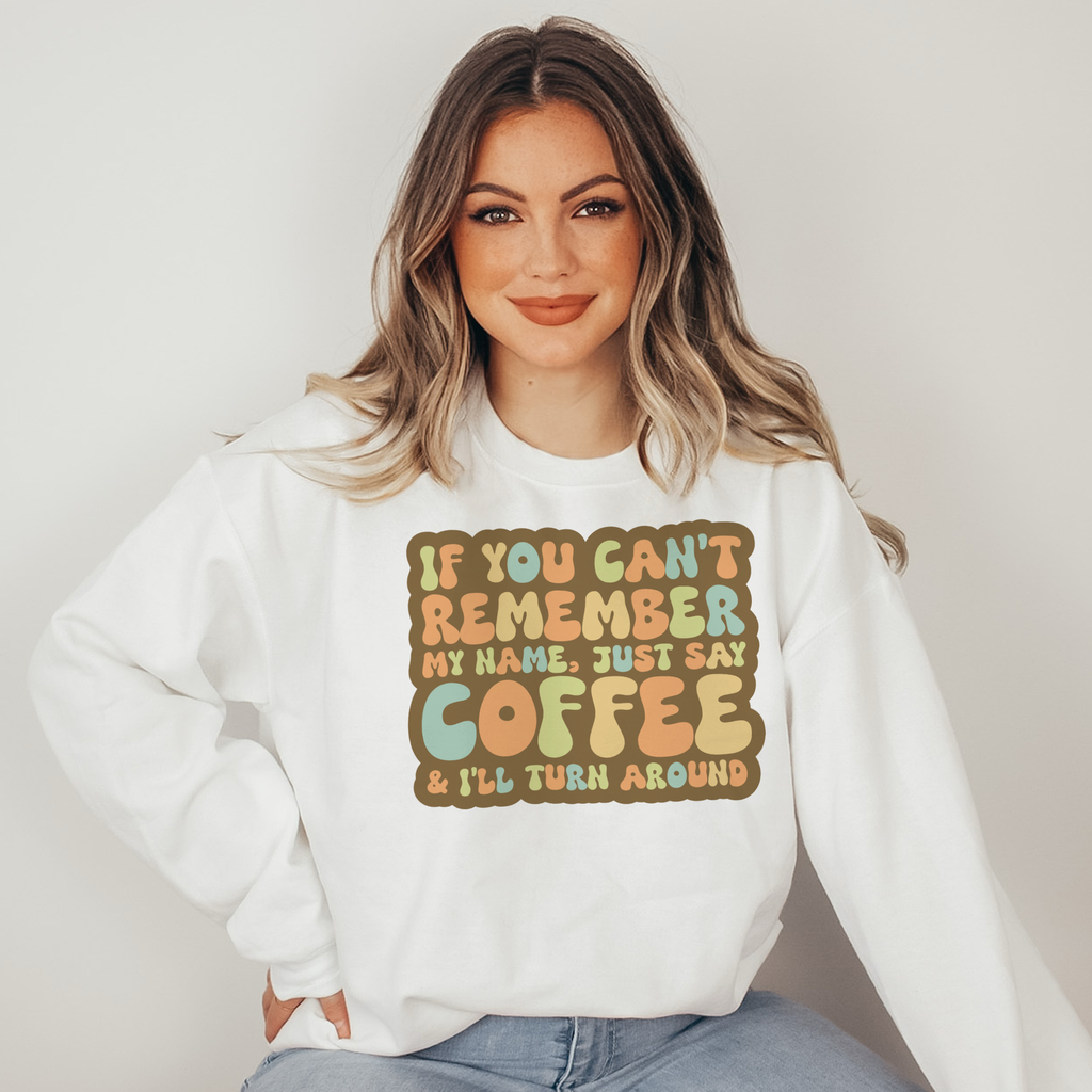 Woman wearing a white sweatshirt with colorful text design on a plain background