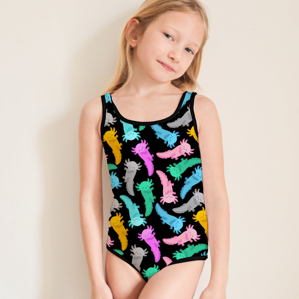 Young girl wearing a colorful axolotl patterned leotard against a plain background