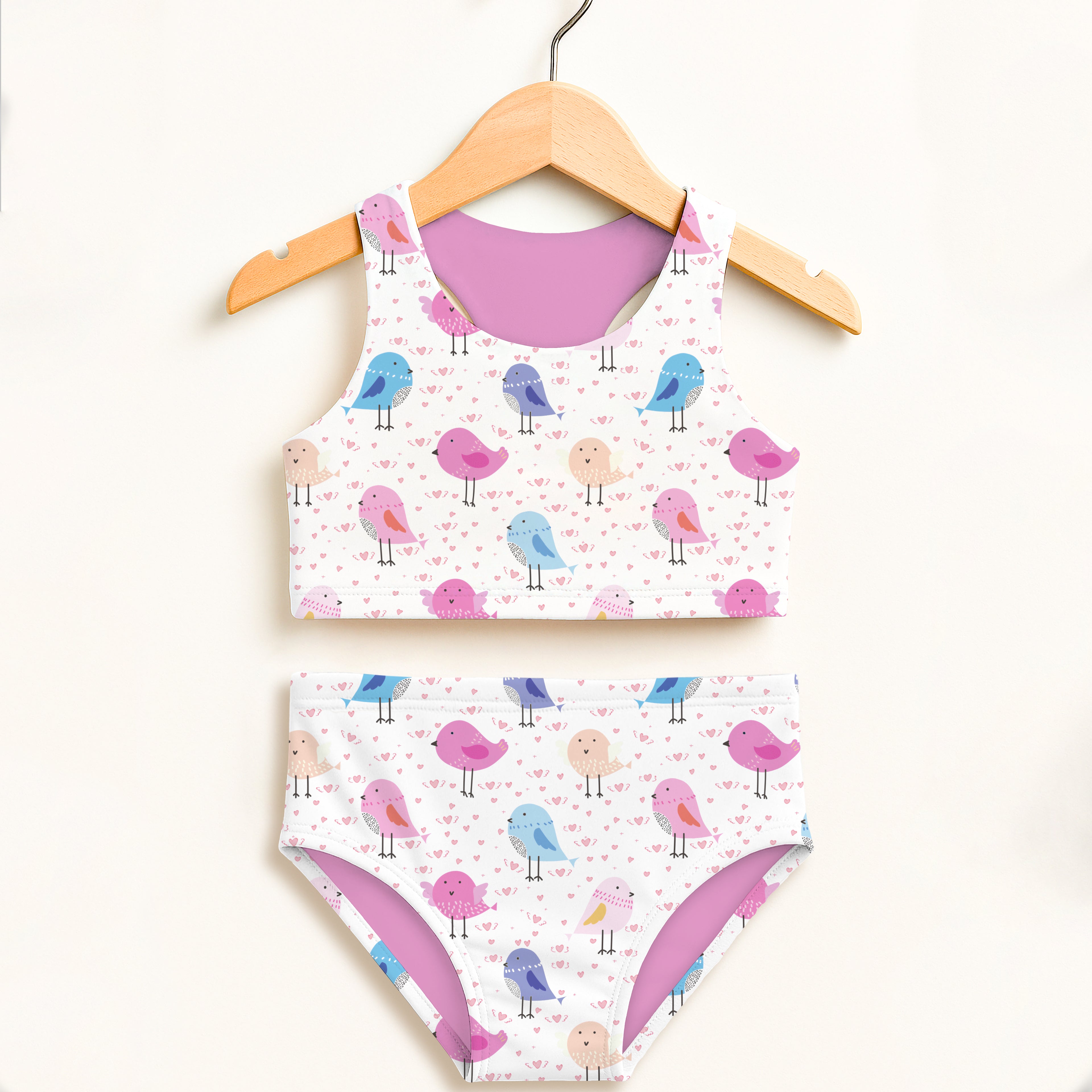 A charming white two-piece girls swimsuit with pastel birds and hearts pattern featuring upf 50 plus high waist design