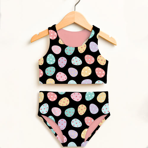 Girls colorful eggs two piece swimsuit in black with pastel easter egg pattern tiny hearts pink lining and upf 50+ protection