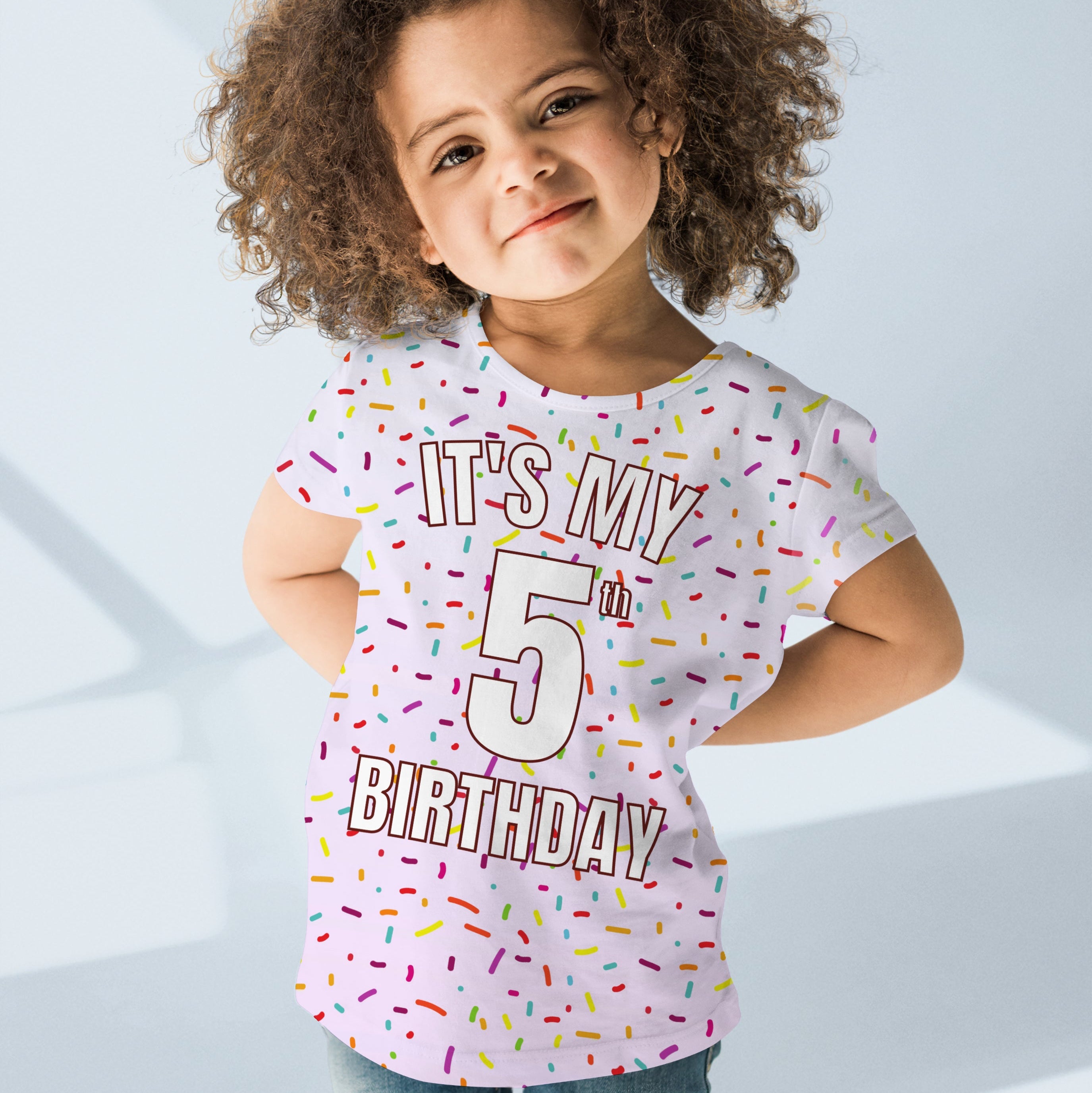 A white cotton girls t-shirt with colorful sprinkle print and bold outlined its my 5th birthday text