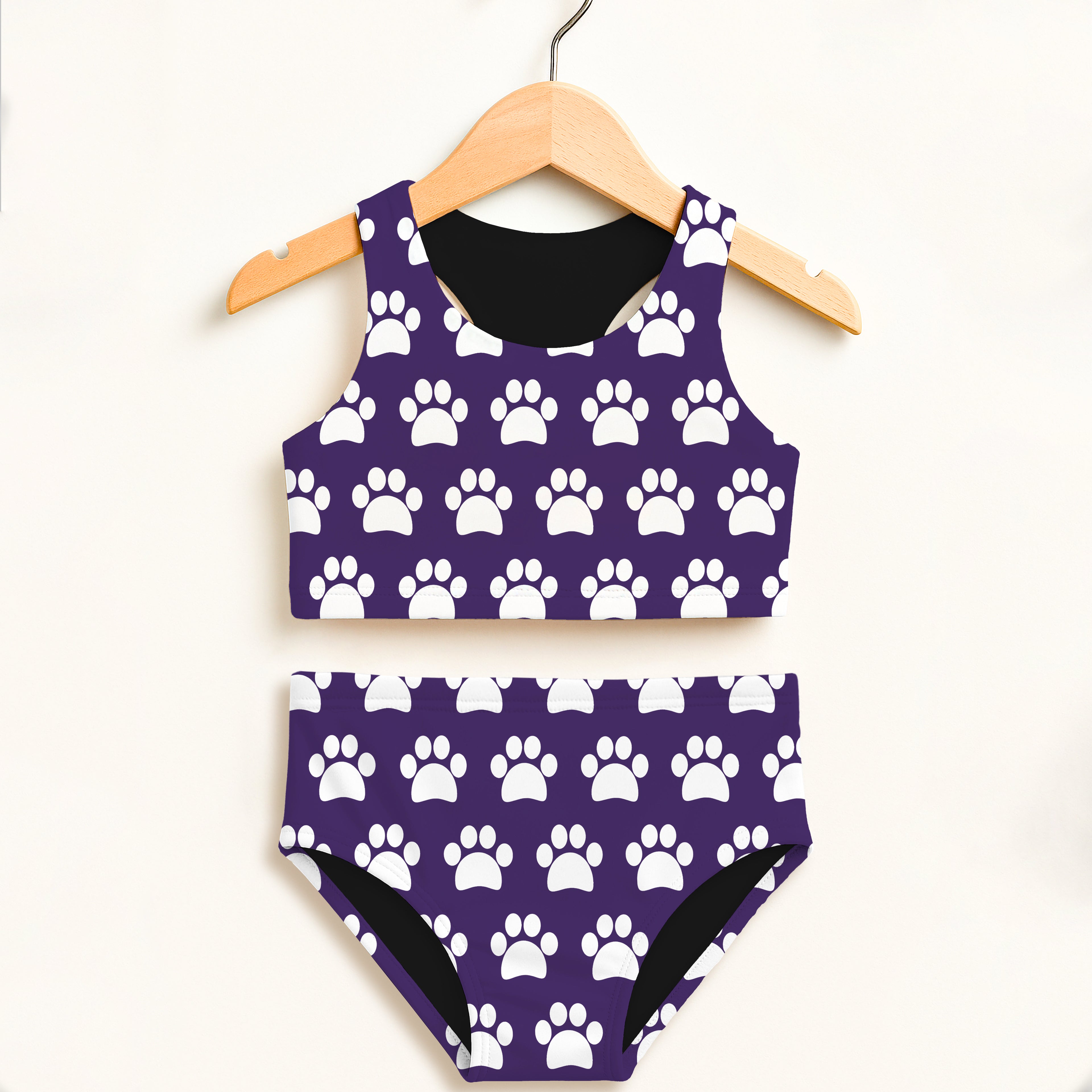 Girls dark purple two piece swimsuit with white paw print pattern black lining and double layered UPF 50 plus fabric