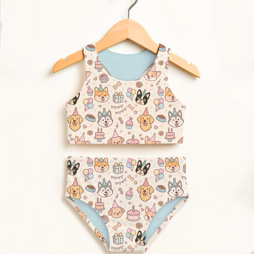 Girls dog birthday two piece swimsuit cream fabric with cartoon dogs party hats birthday cakes and balloons design