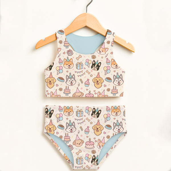 Girls dog birthday two piece swimsuit cream fabric with cartoon dogs party hats birthday cakes and balloons design