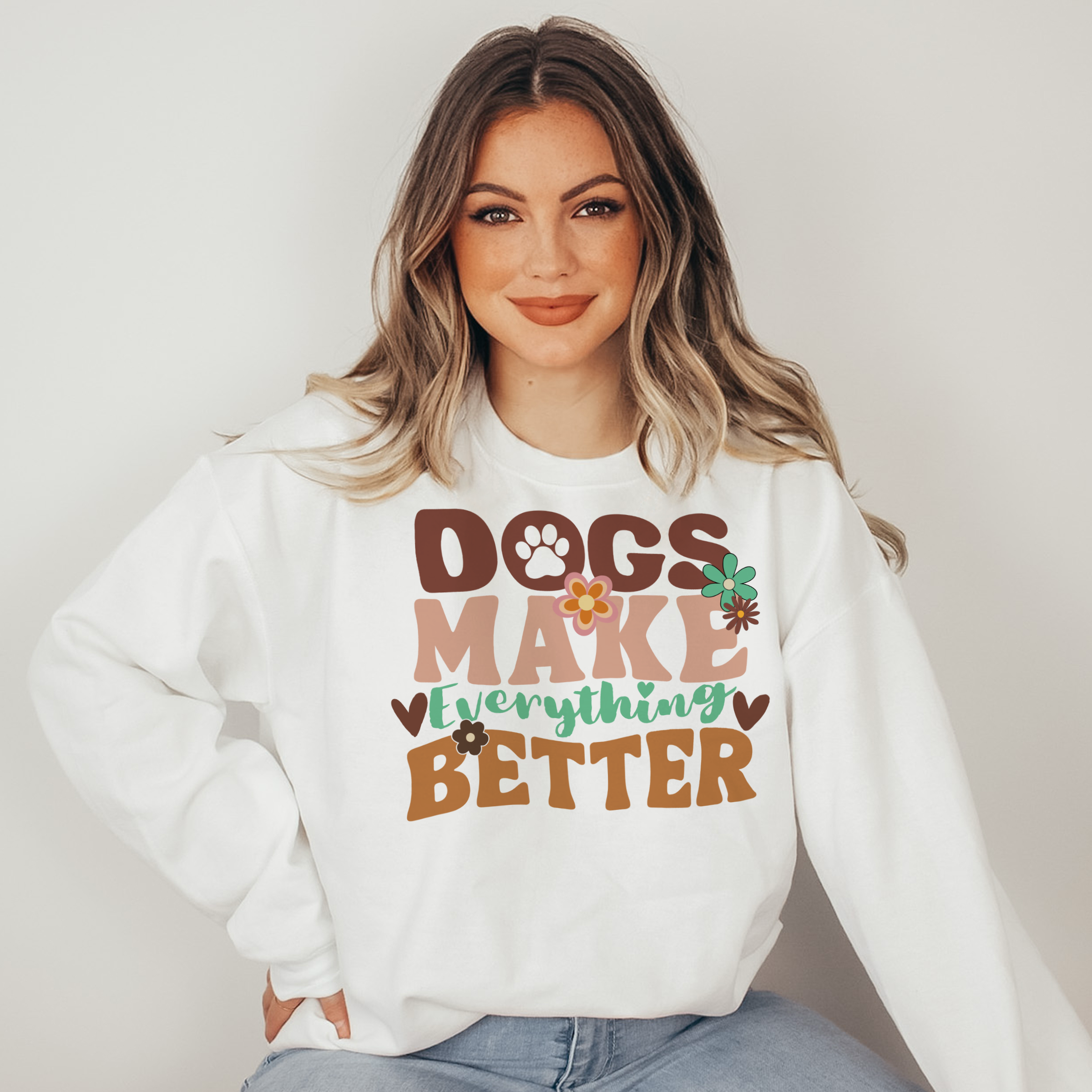 Woman wearing a white sweatshirt with 'DOGS MAKE EVERYTHING BETTER' text.