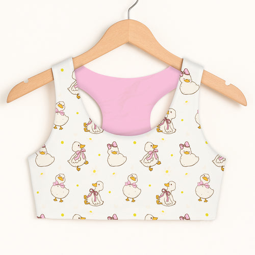 Girls easter duck sports bra in white with playful cartoon ducks pattern and soft pink quick drying lining