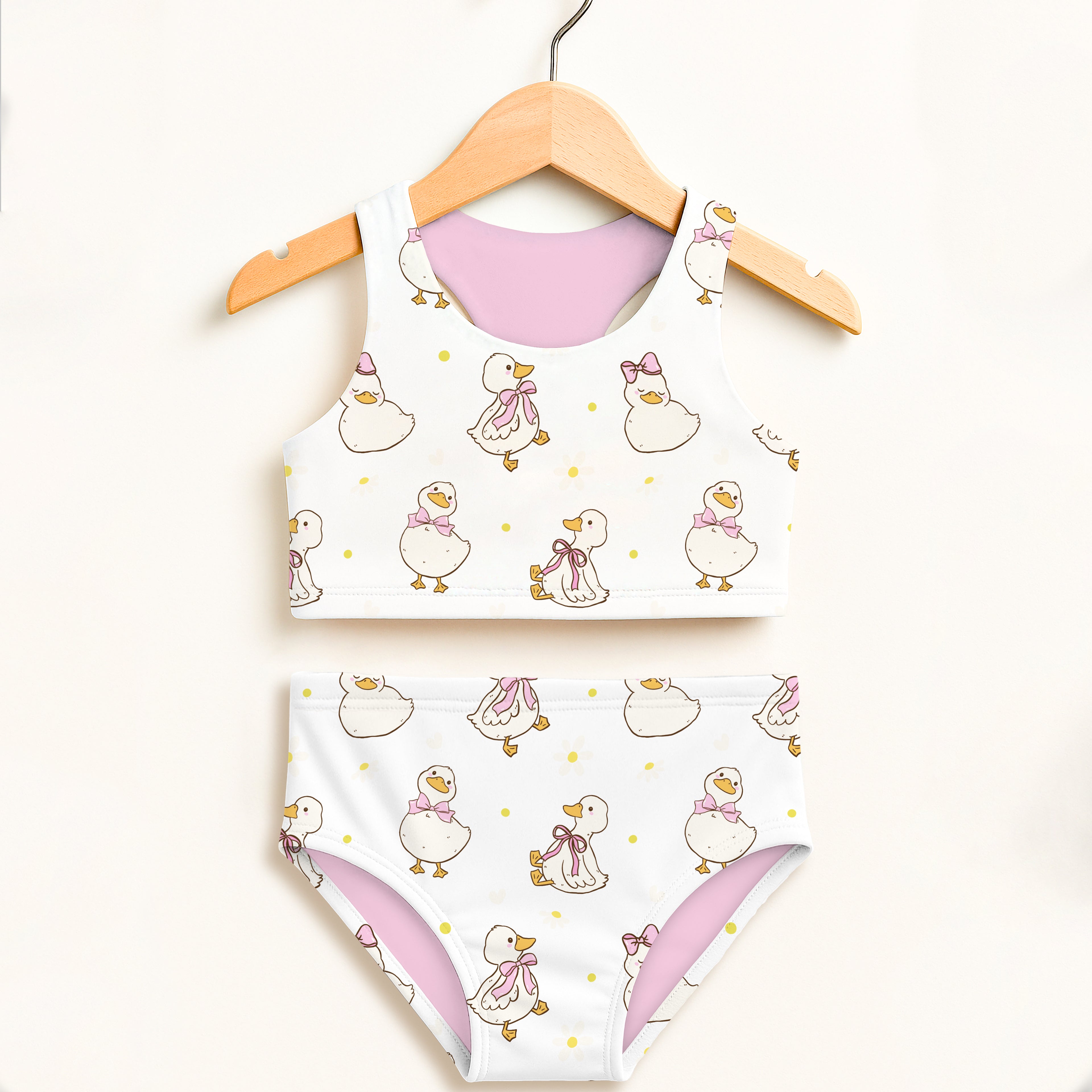Girls white two-piece swimsuit with playful duck pattern pink inner lining double layered UPF 50 plus high waisted comfort