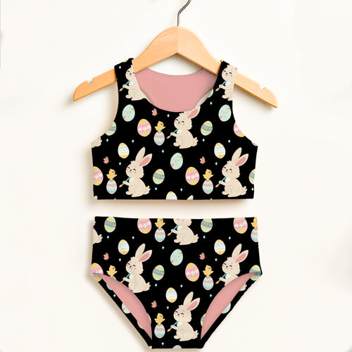 Girls black Easter bunny and chick two piece swimsuit with pink lining featuring cartoon bunnies and colorful eggs