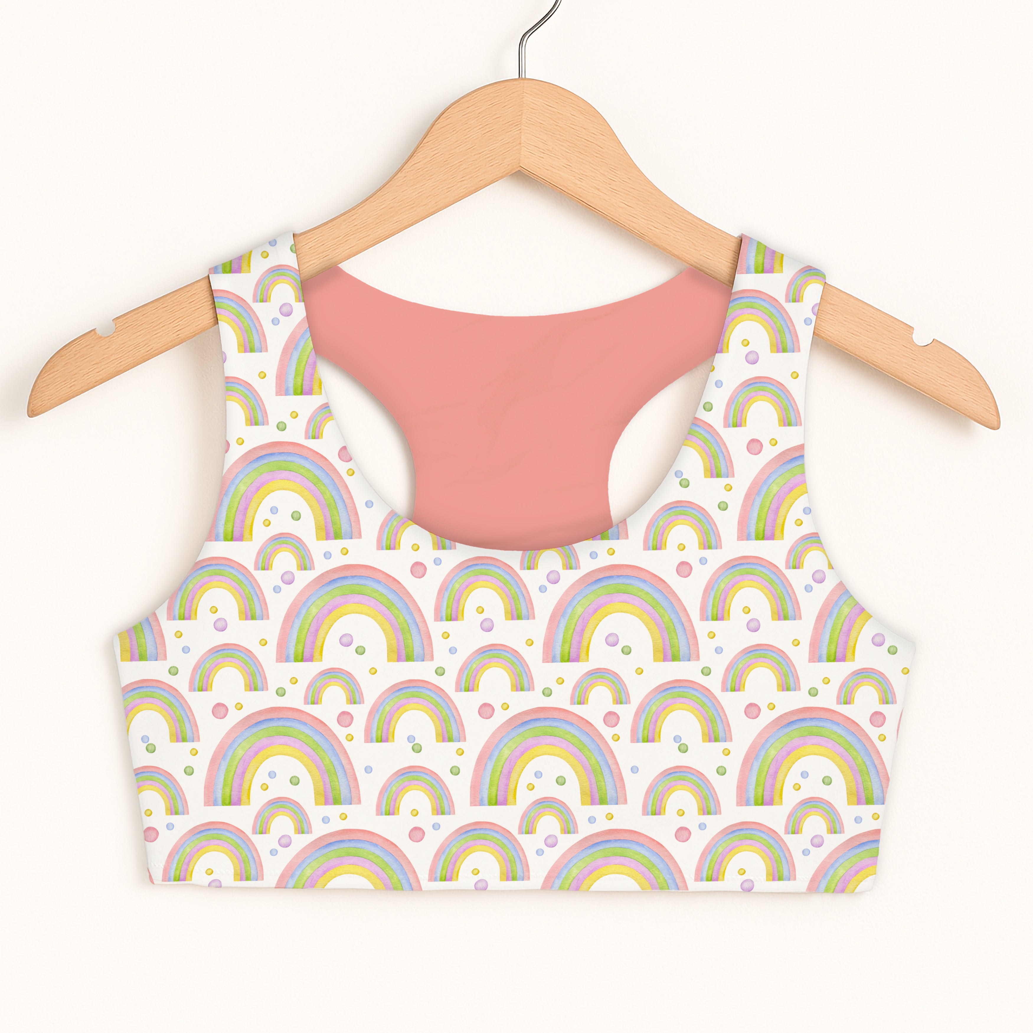 Girls pastel rainbows sports bra with pastel rainbow pattern and soft pink interior lining for quick drying comfort