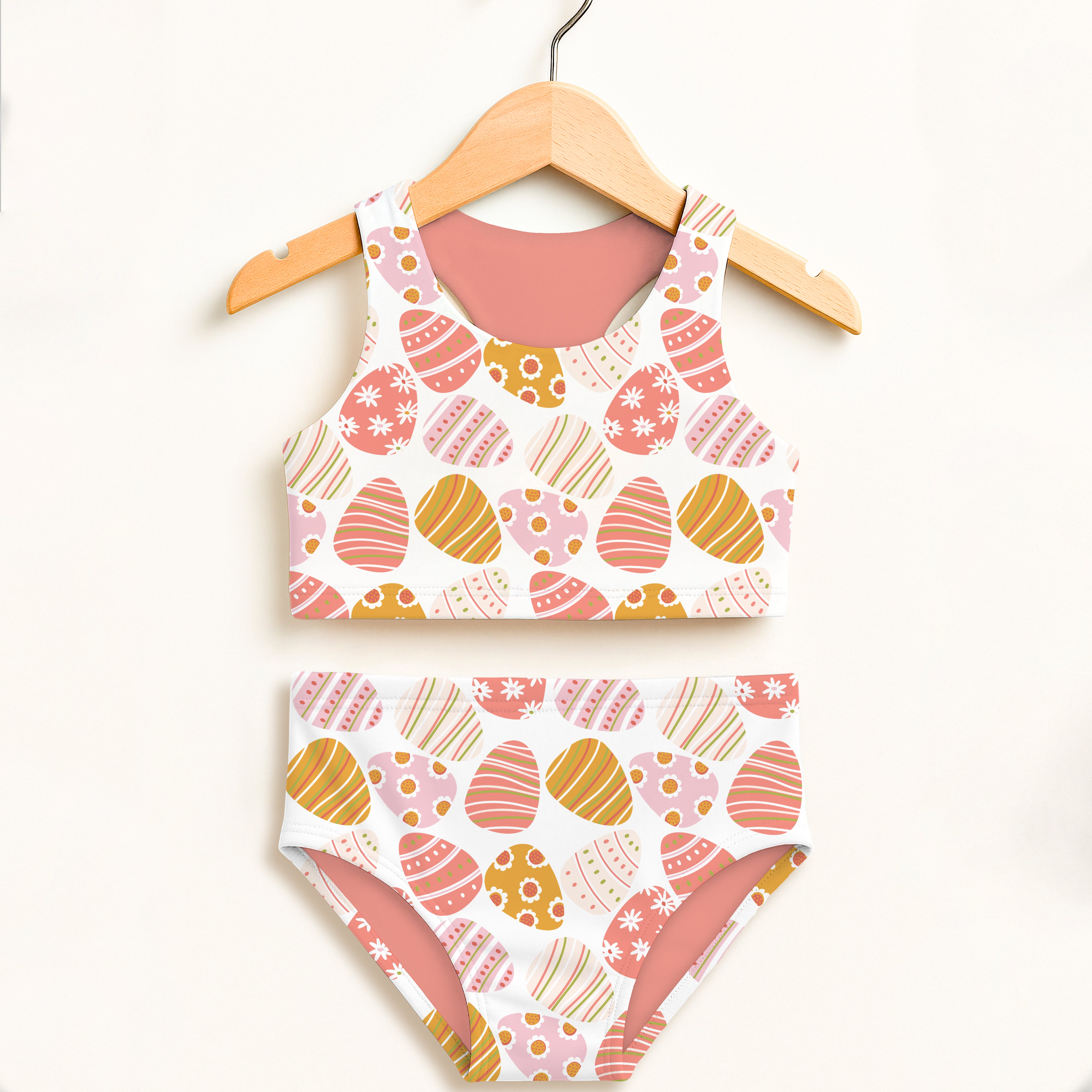 Girls coral two-piece swimsuit with playful pink orange yellow easter egg pattern double layered upf 50+ fabric
