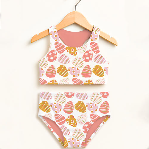 Girls coral two-piece swimsuit with playful pink orange yellow easter egg pattern double layered upf 50+ fabric