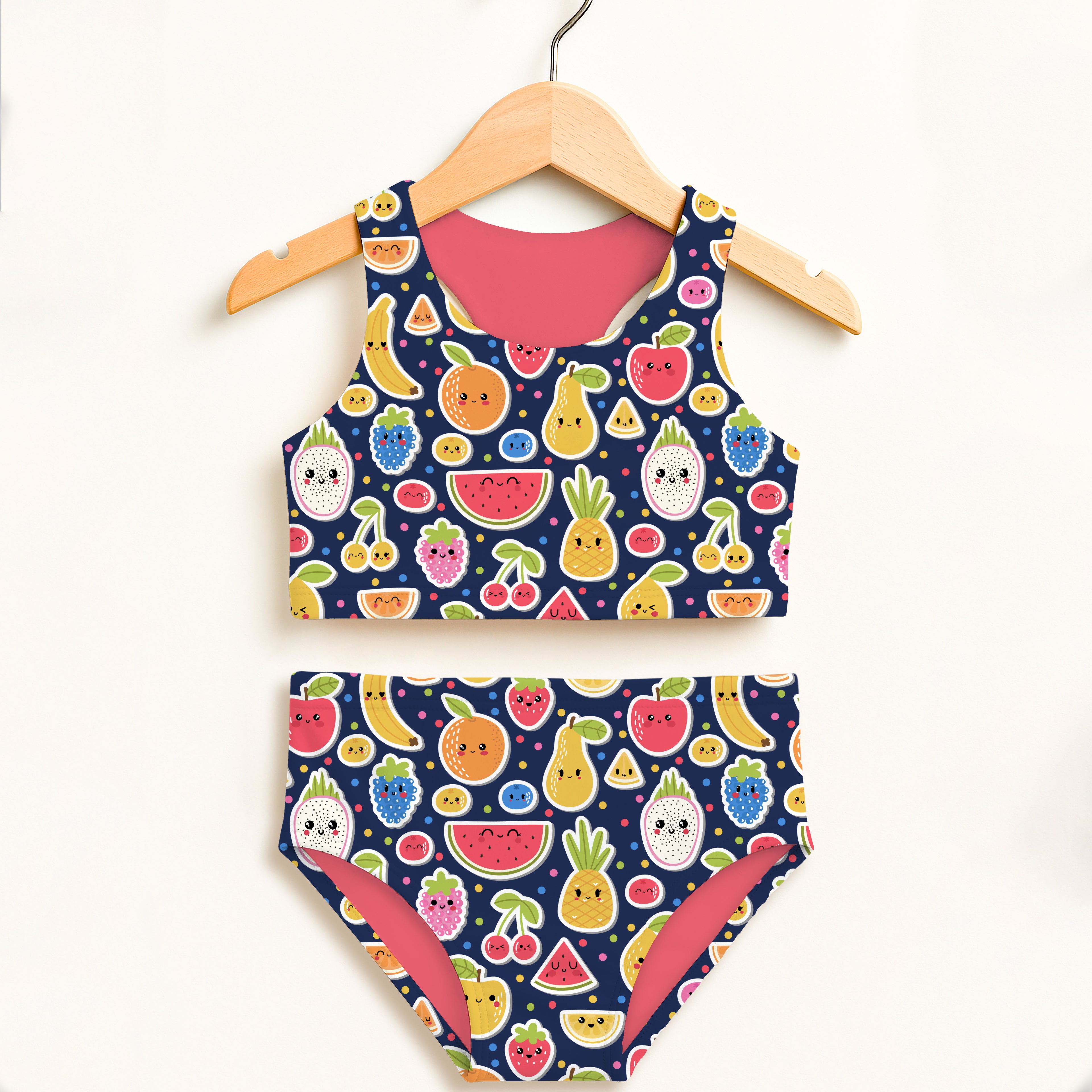 A navy blue girls emoji fruit two piece swimsuit with playful fruit pattern and pink lining, double layered UPF 50 plus