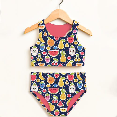 A navy blue girls emoji fruit two piece swimsuit with playful fruit pattern and pink lining, double layered UPF 50 plus