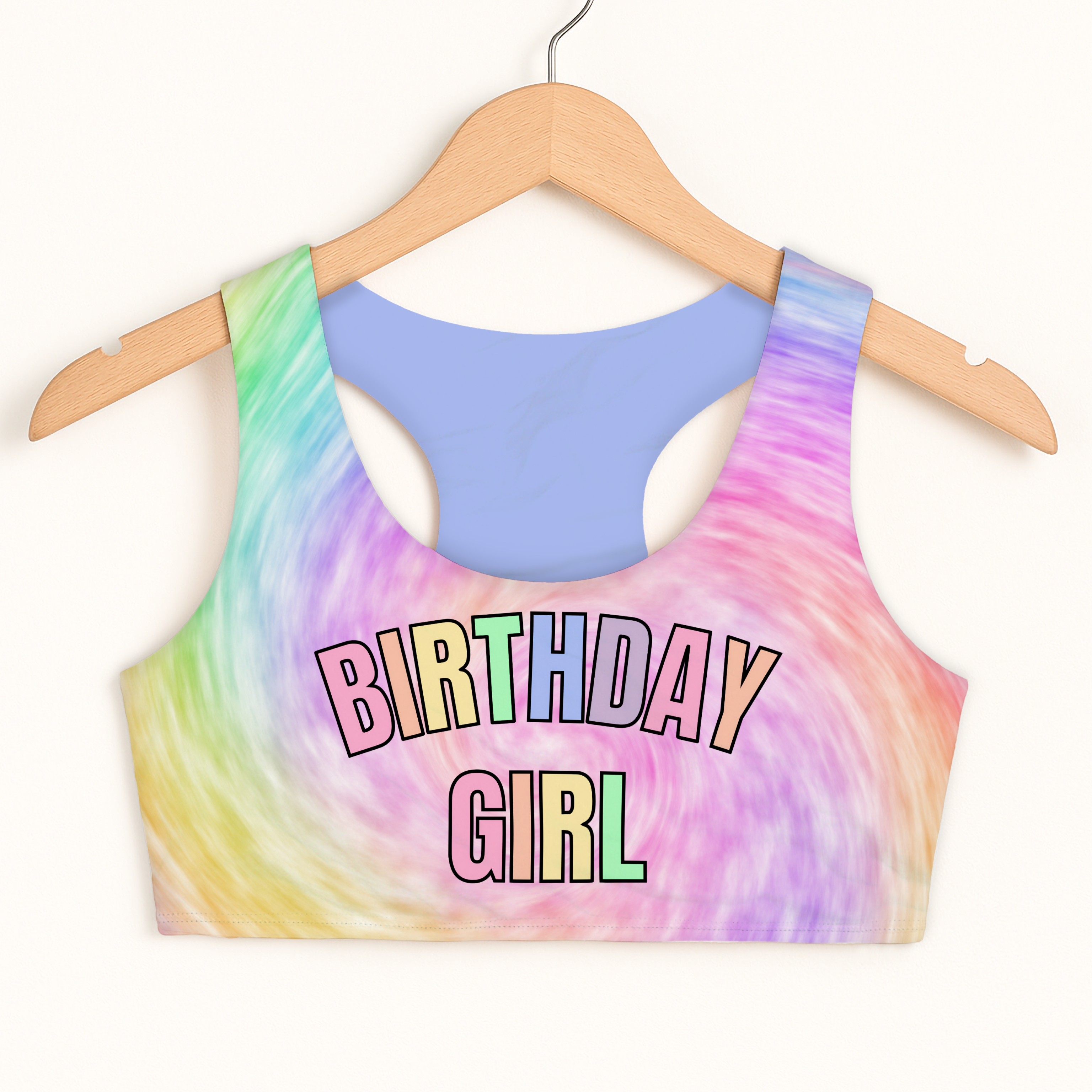 Colorful tie-dye sports bra with 'Birthday Girl' text on a hanger