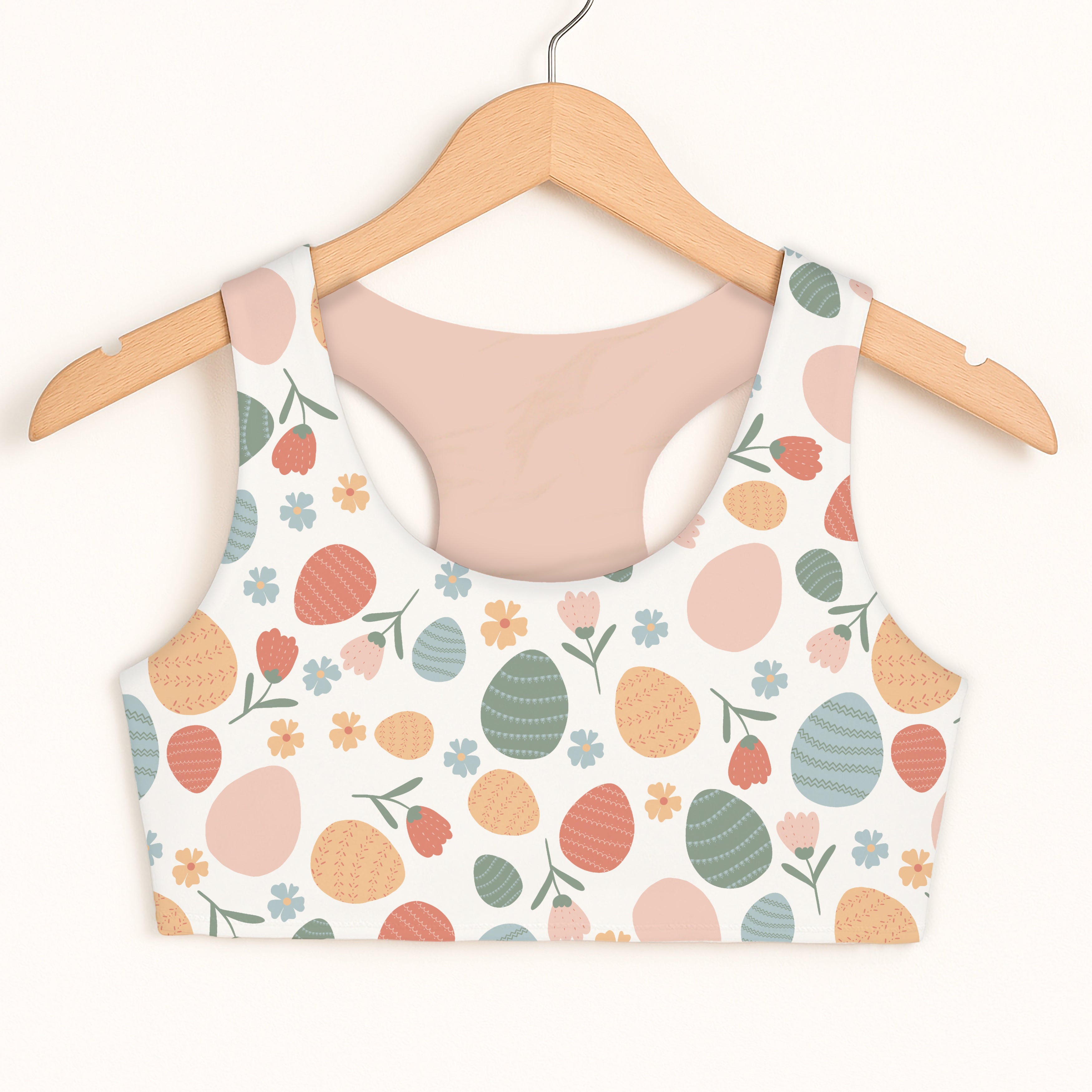 Girls floral themed easter egg sports bra in white with pastel peach teal orange pink egg and flower pattern quick drying