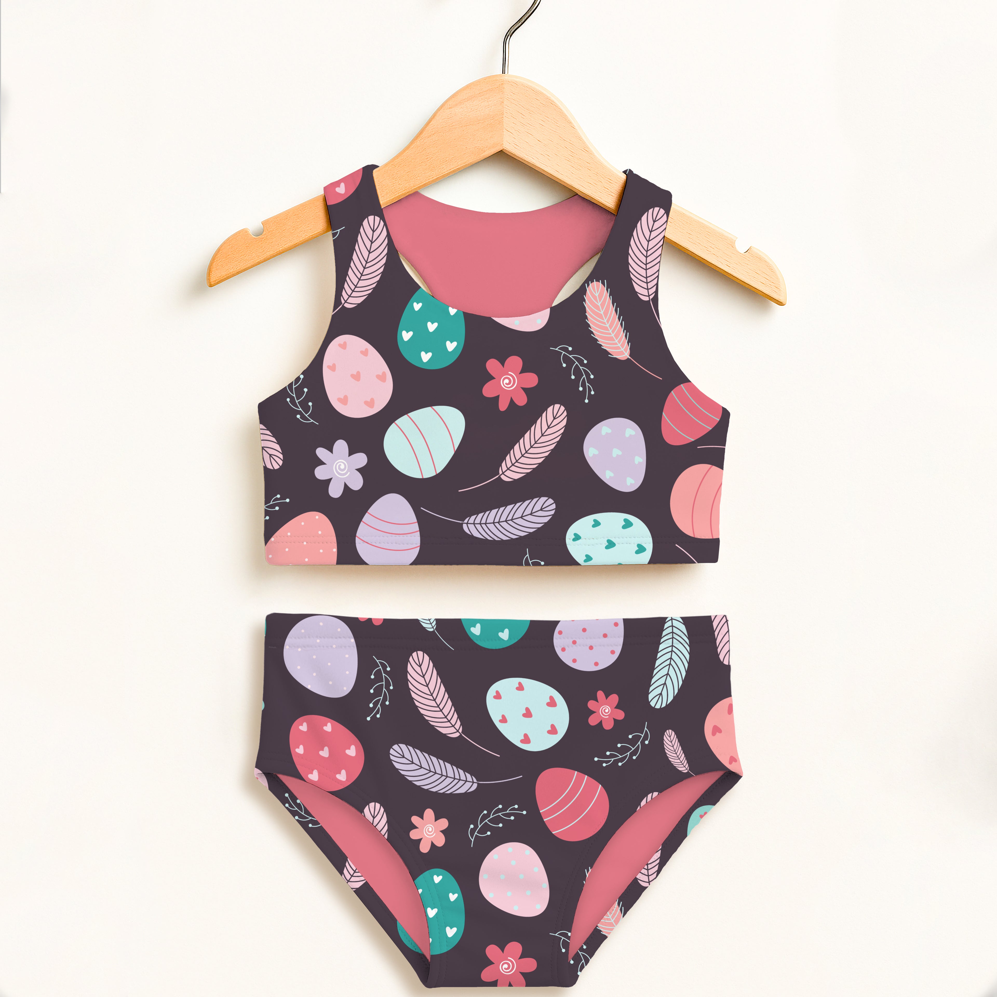 Girls purple floral easter eggs two piece swimsuit with dark navy base colorful pastel eggs feathers and flowers upf 50+