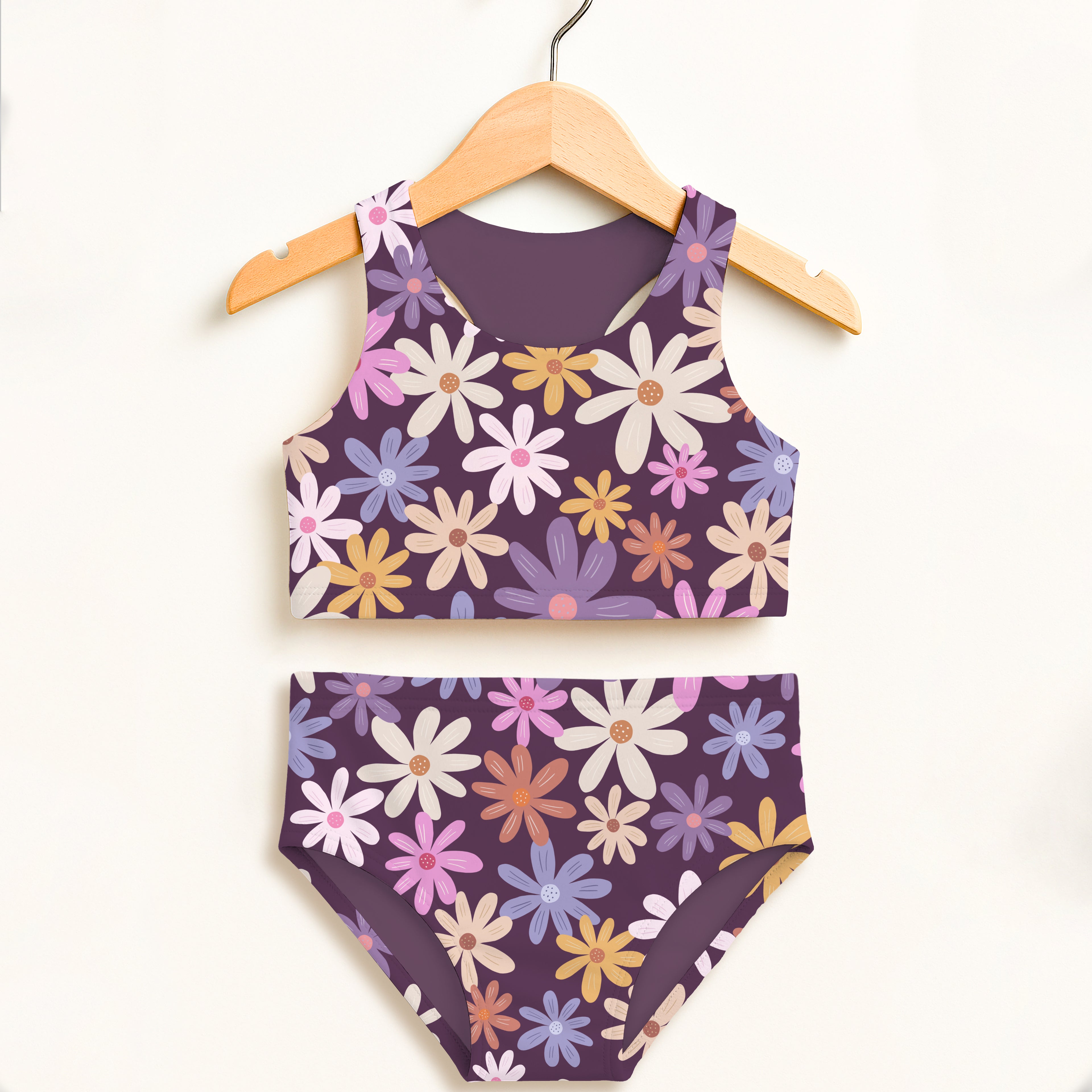 Girls purple floral two piece swimsuit with vibrant white pink blue yellow daisies and double layered upf 50 plus fabric