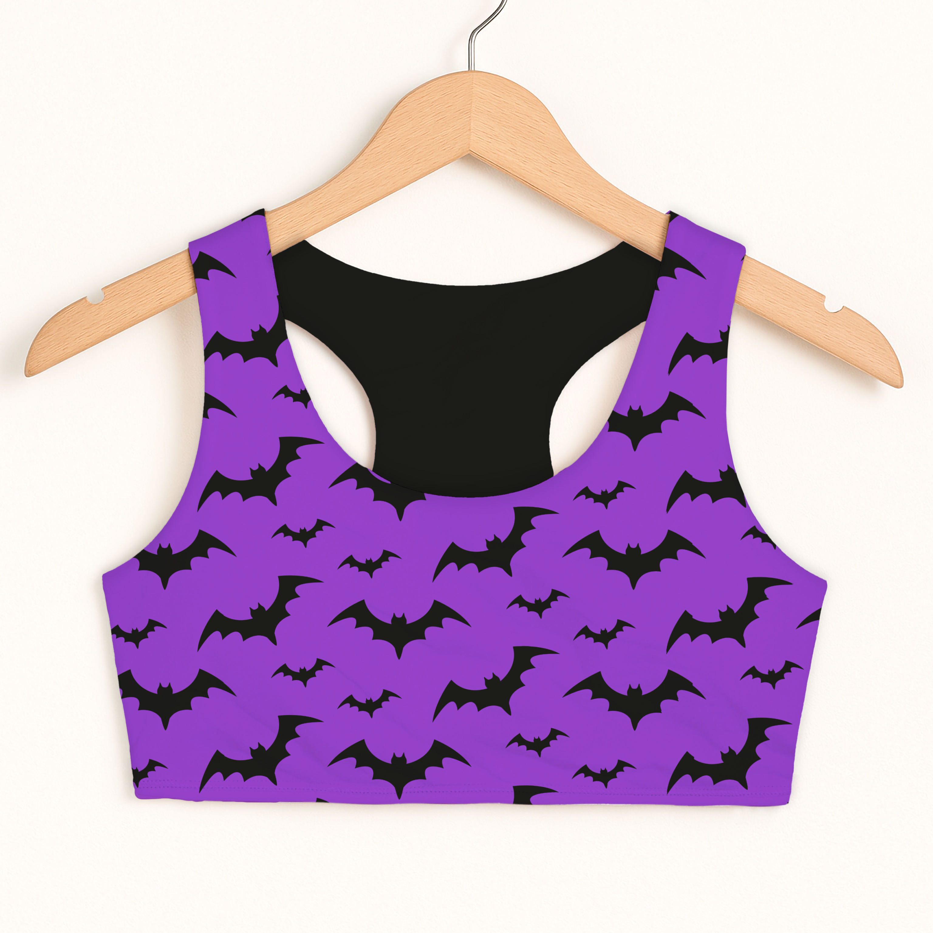 Girls purple bats Halloween sports bra with black pattern and interior lining on wooden hanger for quick drying comfort