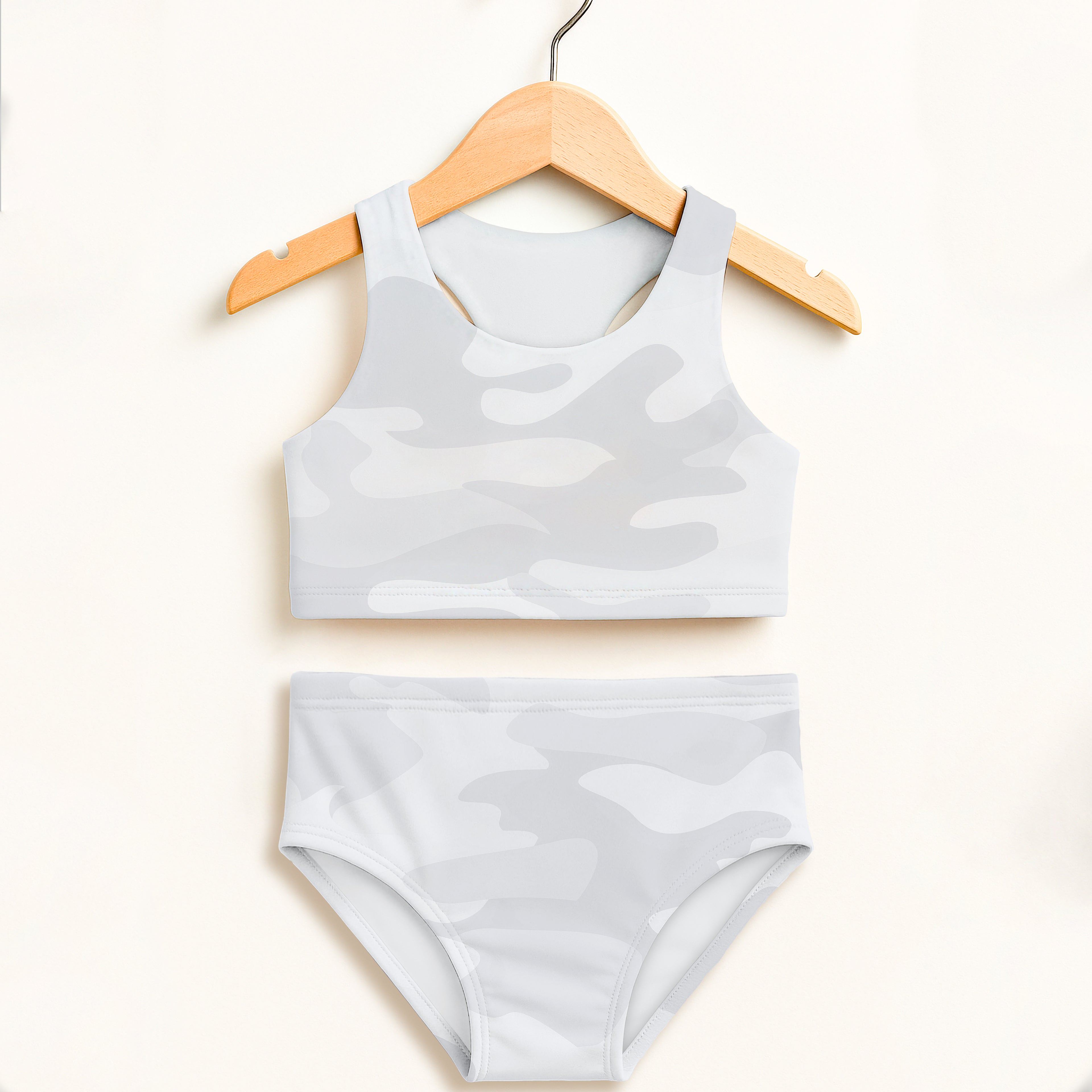 Girls light gray camouflage two piece swimsuit with cropped top and high waisted bottoms featuring upf 50+ protection