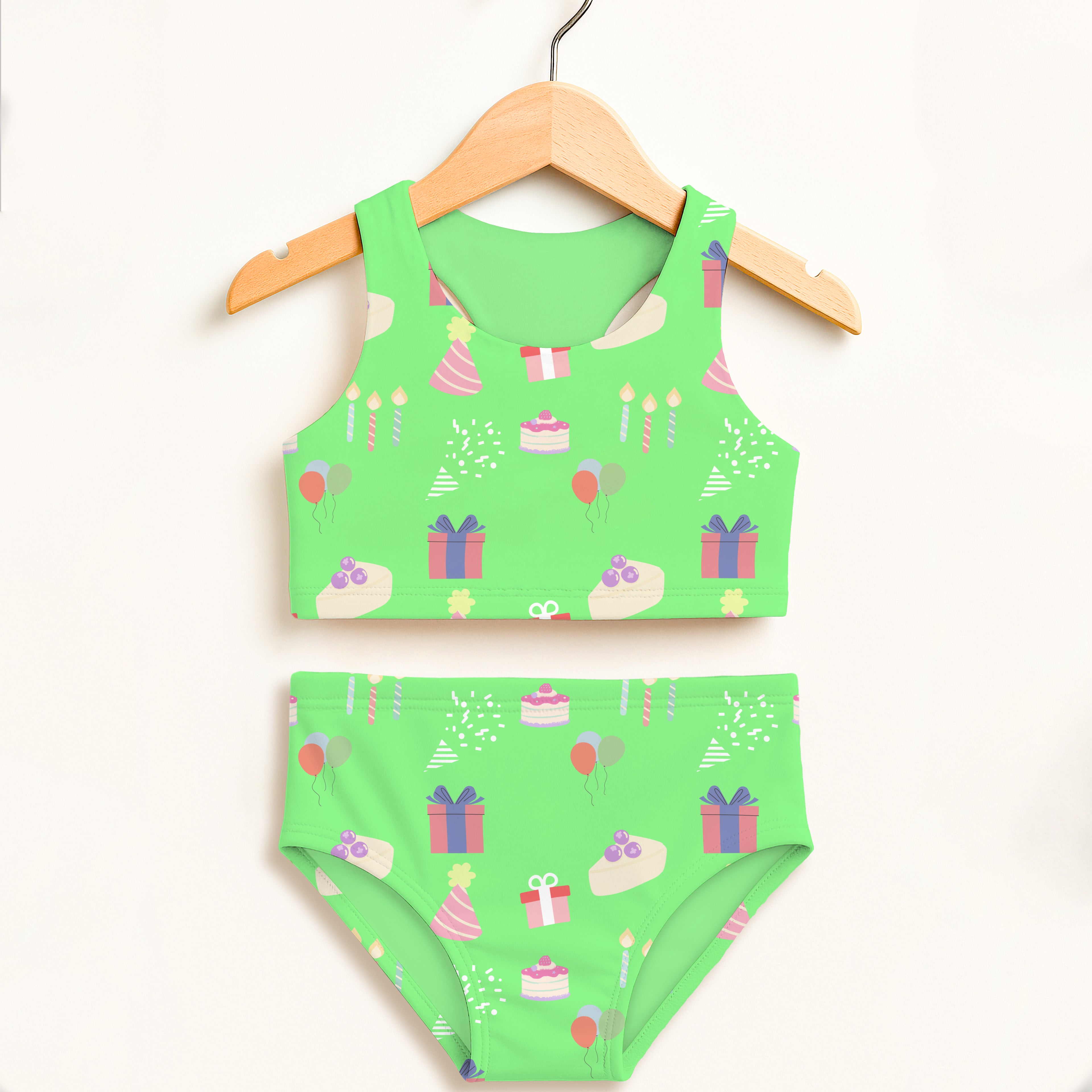 Girls green birthday party two piece swimsuit with playful cake gift and balloon print and double layered upf 50+ fabric