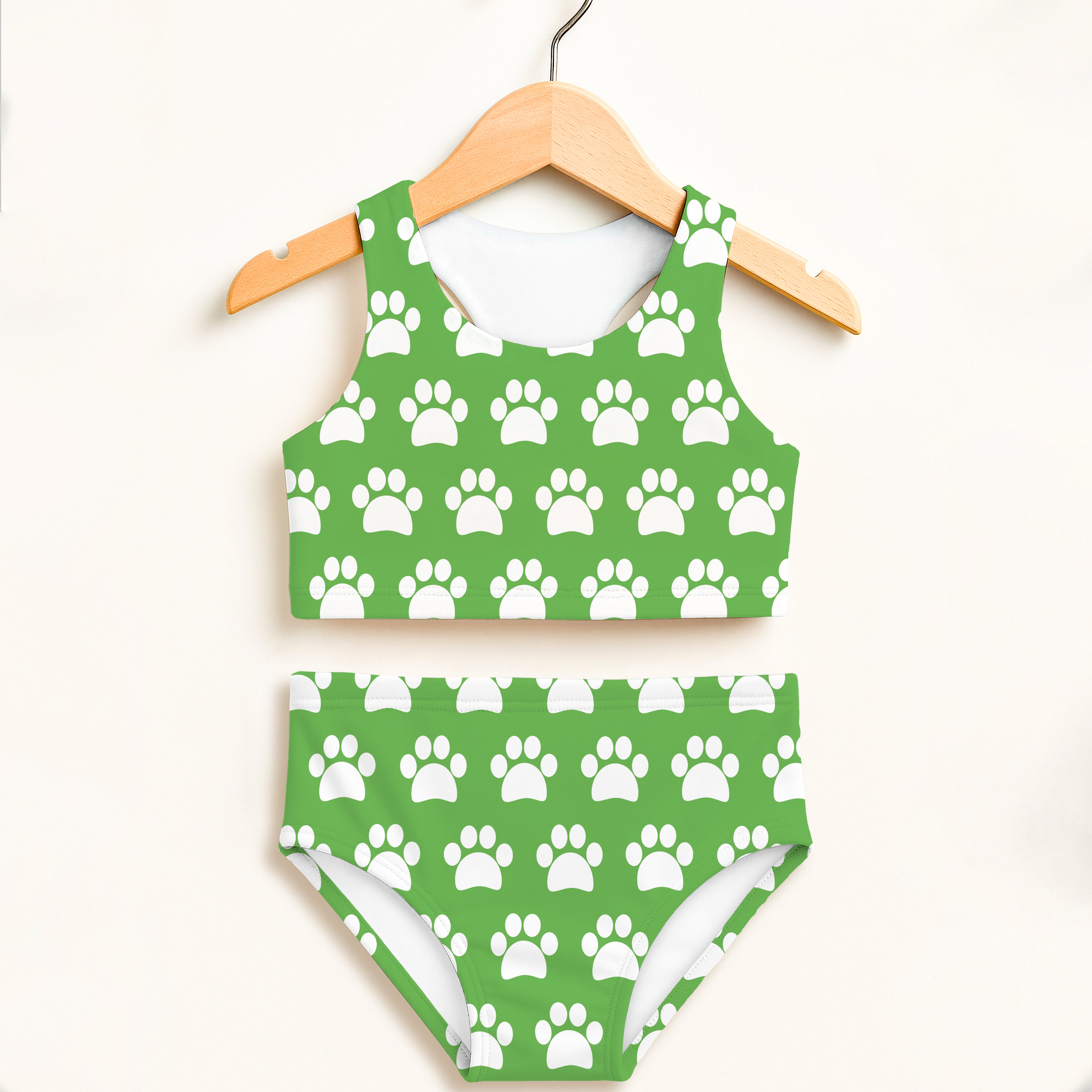 Girls green two piece swimsuit with white paw print pattern halter top and high waisted double layered upf 50 plus