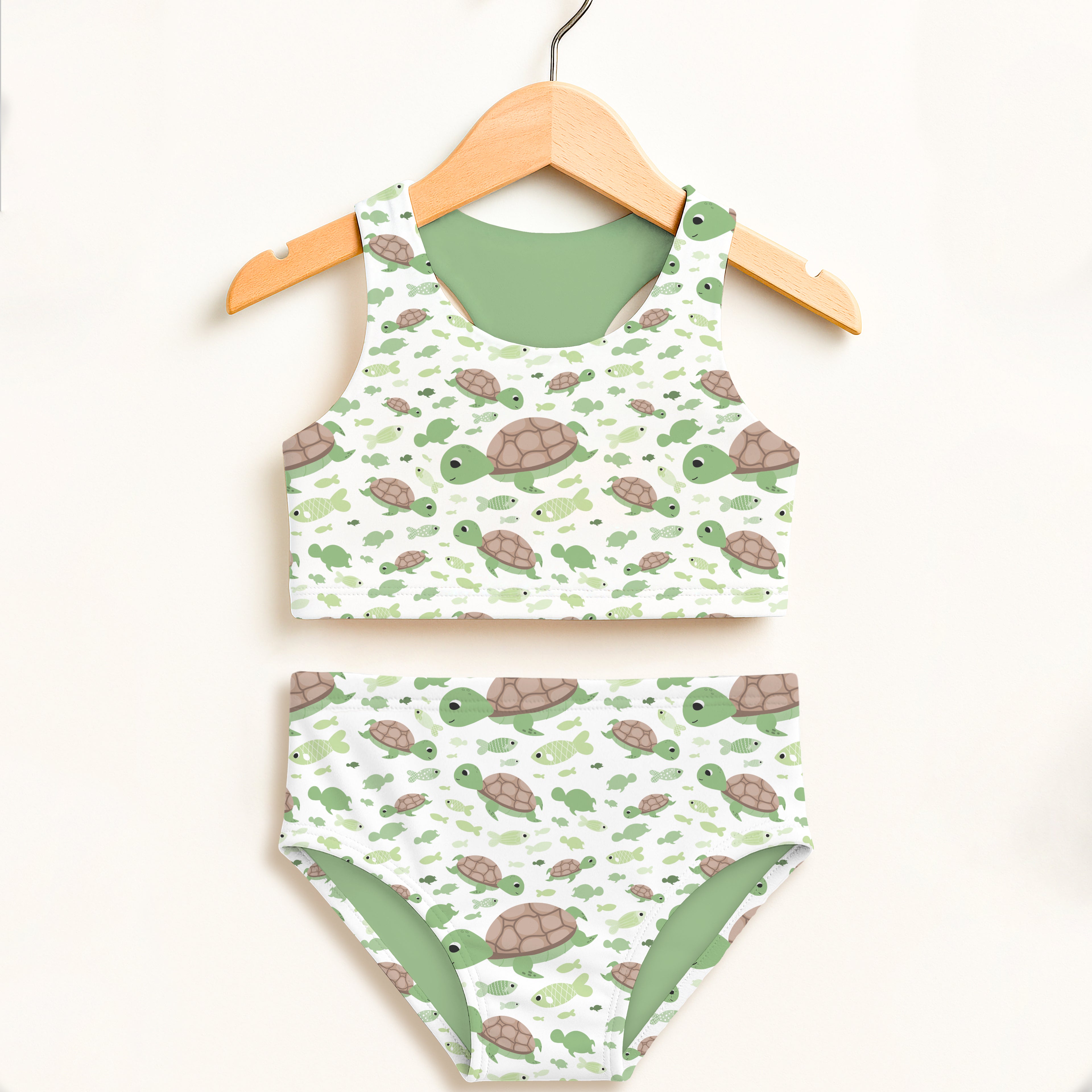 Girls green sea turtles two piece swimsuit with playful turtle pattern on white and solid sage green lining