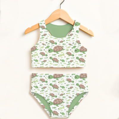 Girls green sea turtles two piece swimsuit with playful turtle pattern on white and solid sage green lining