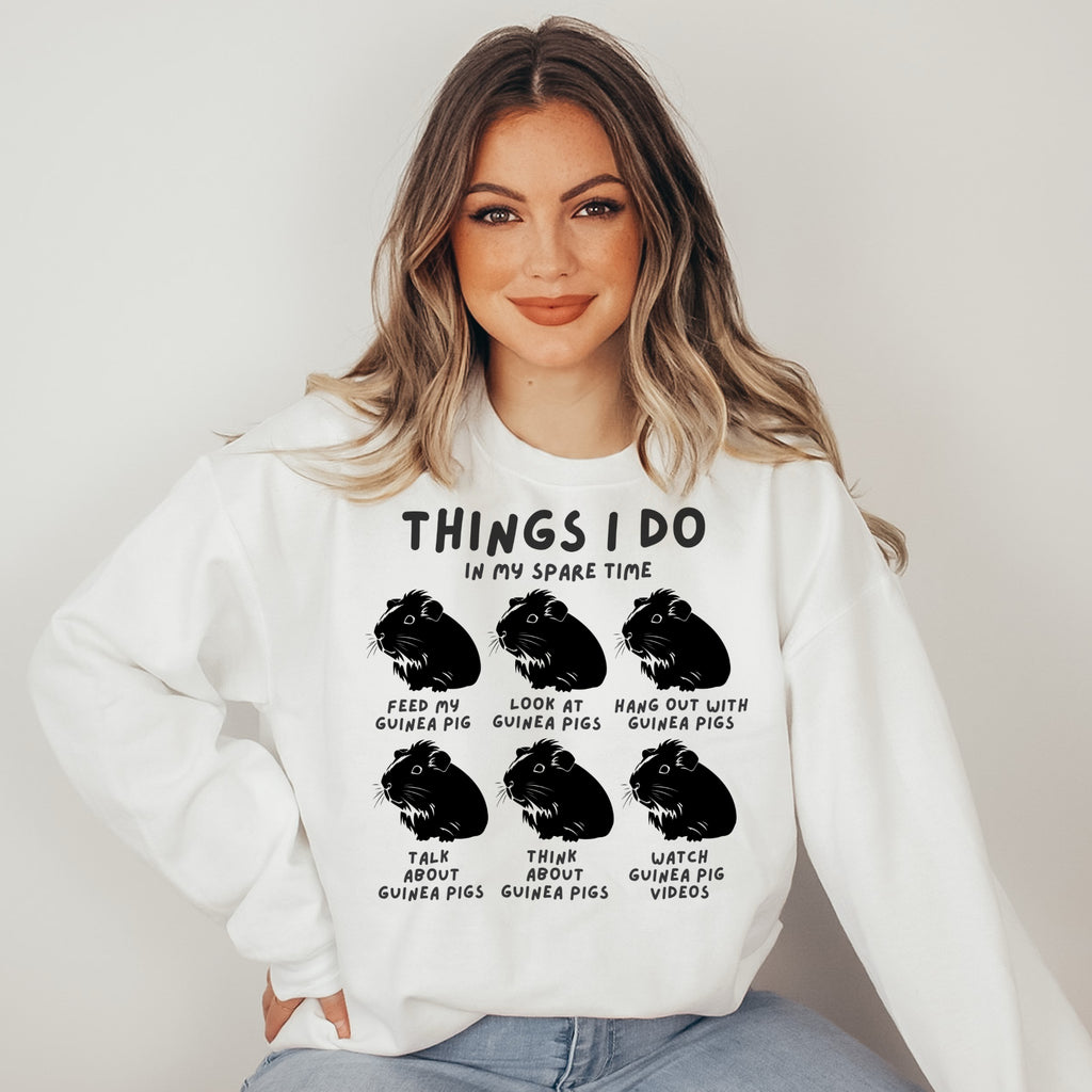 Woman wearing a white sweatshirt with black text and guinea pig illustrations on a plain background