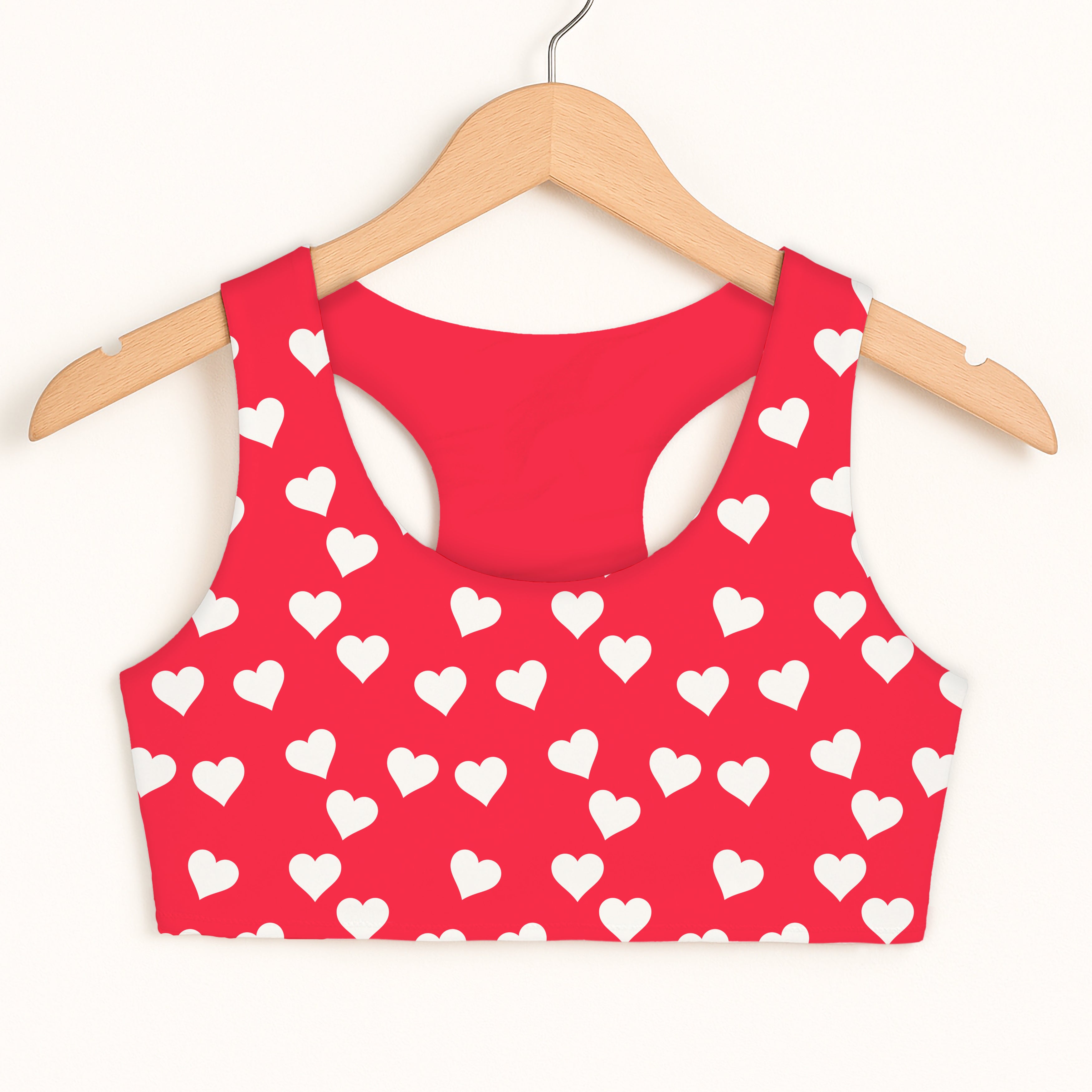 Red girls sports bra with white heart pattern quick drying double layered comfort hanging on wooden hanger