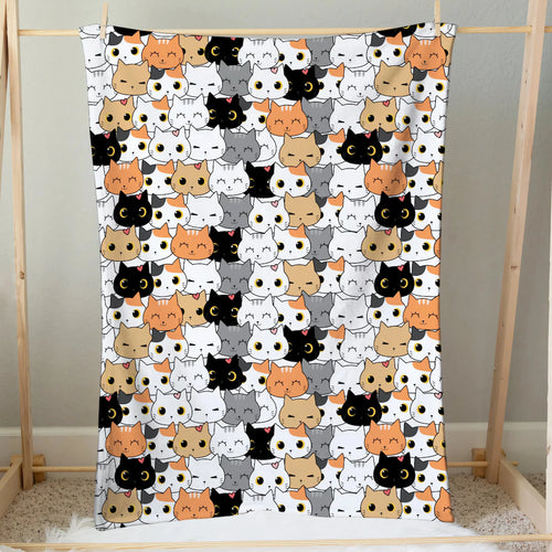 A girls cat face blanket with a cozy playful pattern of black white orange and gray cartoon cats on soft fabric