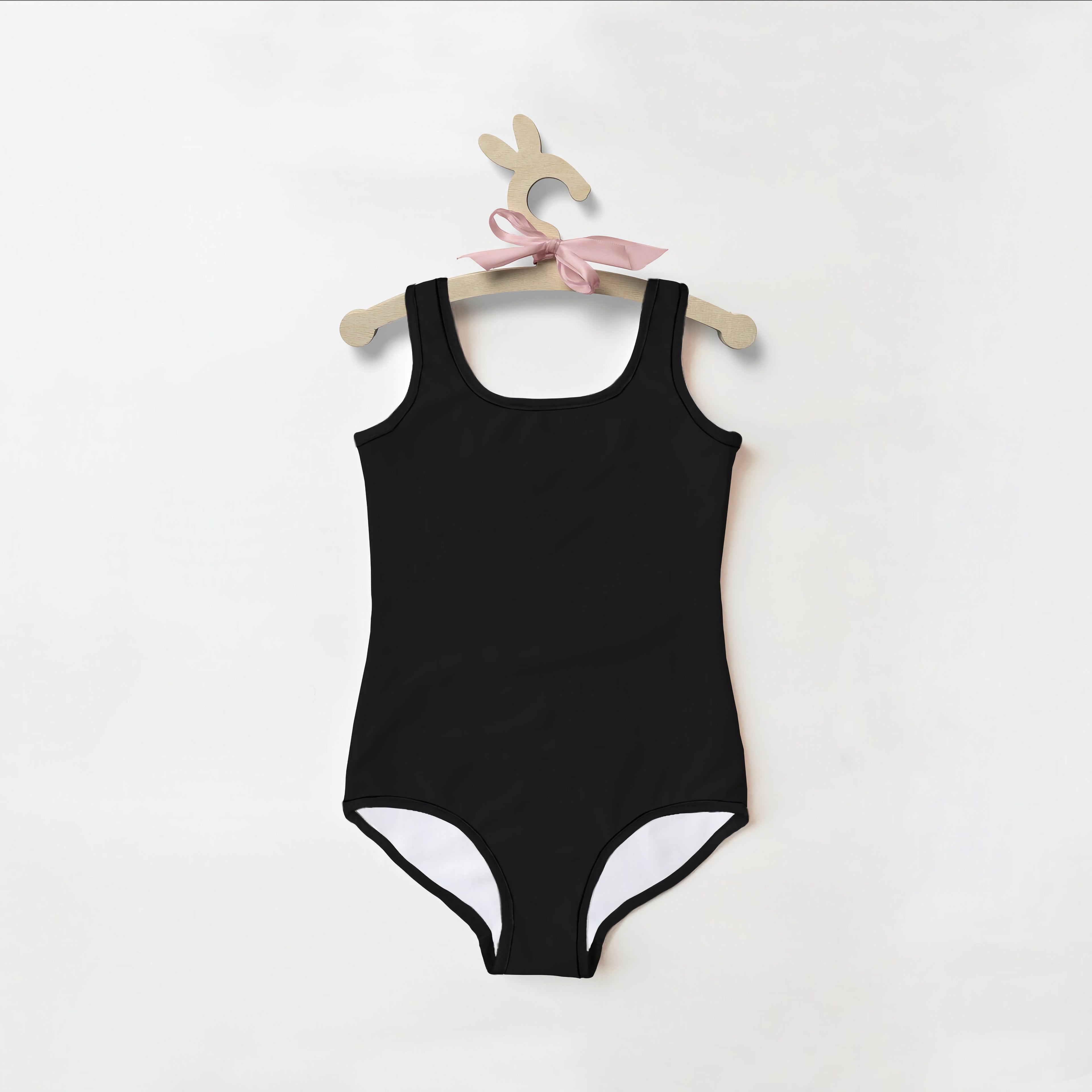 Girls buttery soft black one-piece swimsuit with white lining and upf 50 plus hanging on wooden bunny hanger