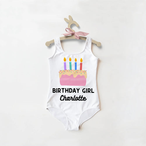 White one-piece swimsuit featuring a colorful birthday cake graphic and birthday girl charlotte text below for parties