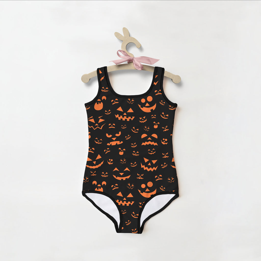 Girls jack-o-lantern faces halloween swimsuit in black with orange pumpkin prints and white leg lining featuring a square neckline