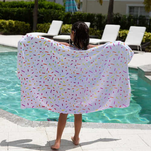 A white beach towel for girls featuring a playful multicolored sprinkle pattern perfect for summer use